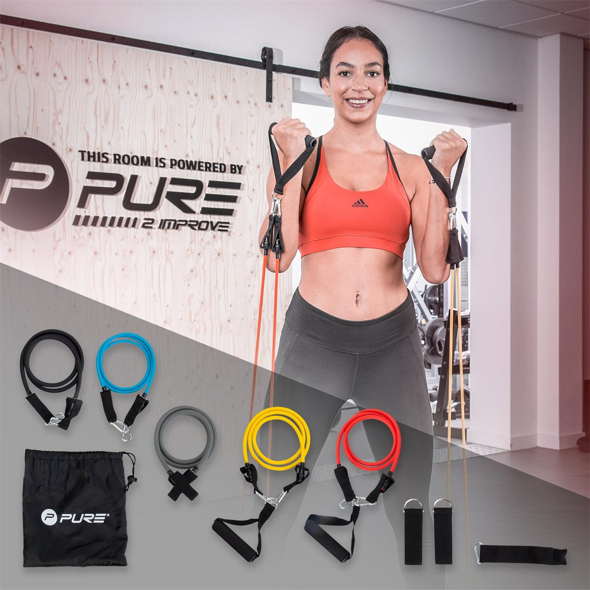 Žena ve sportovním oblečení drží odporové gumy ve fitness centru.
