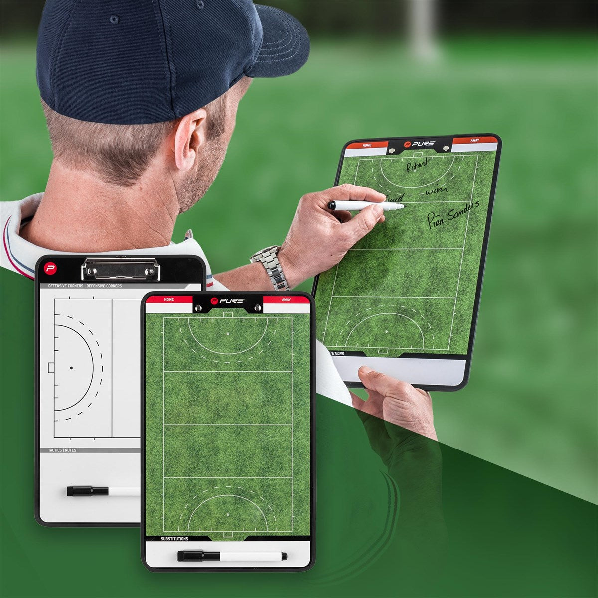 Entrenador con tableros tácticos en un campo deportivo.