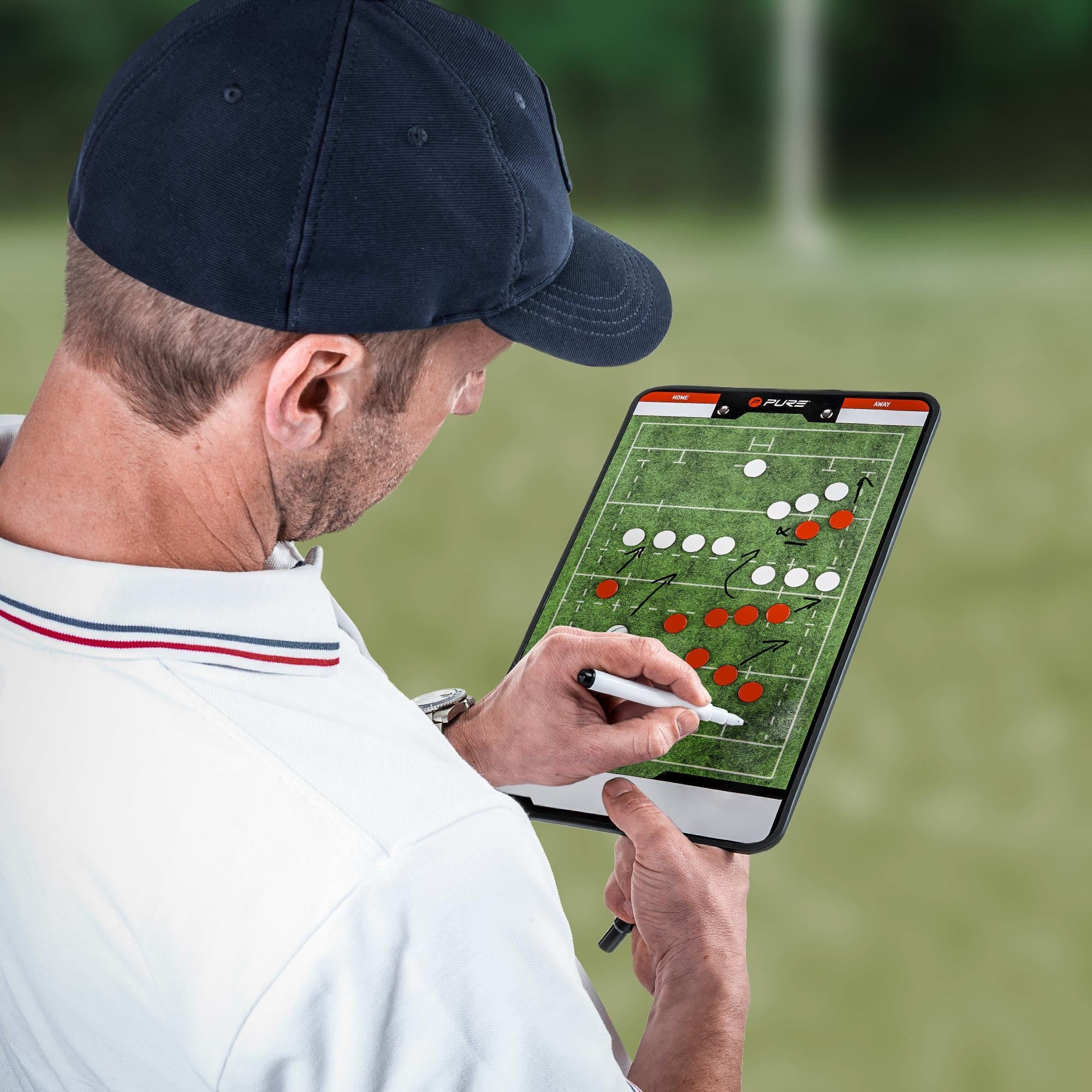 Uomo con cappello che schizza una tattica sportiva su un tablet.