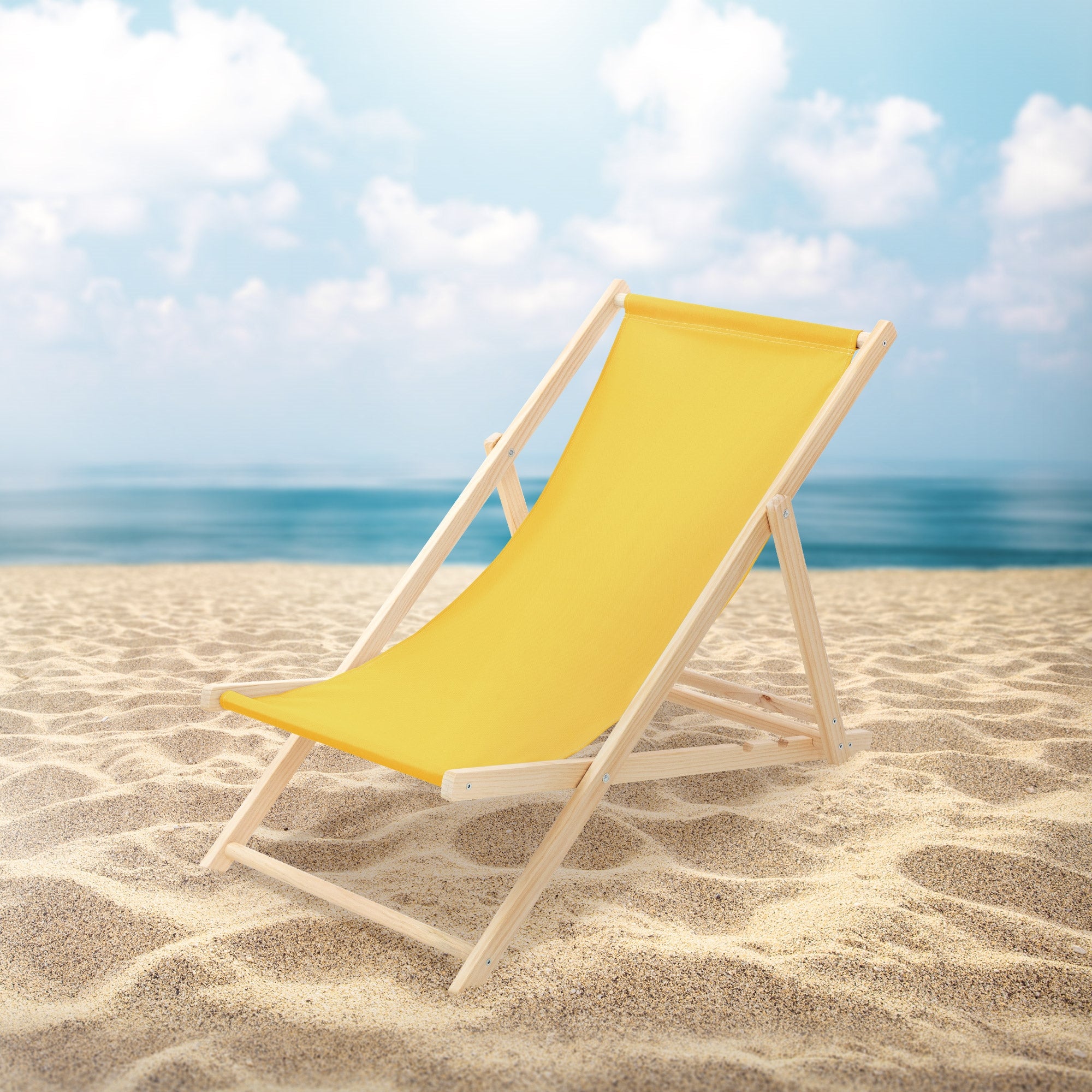 Sárga fa napozóágy a strandon, háttérben a tengerrel.