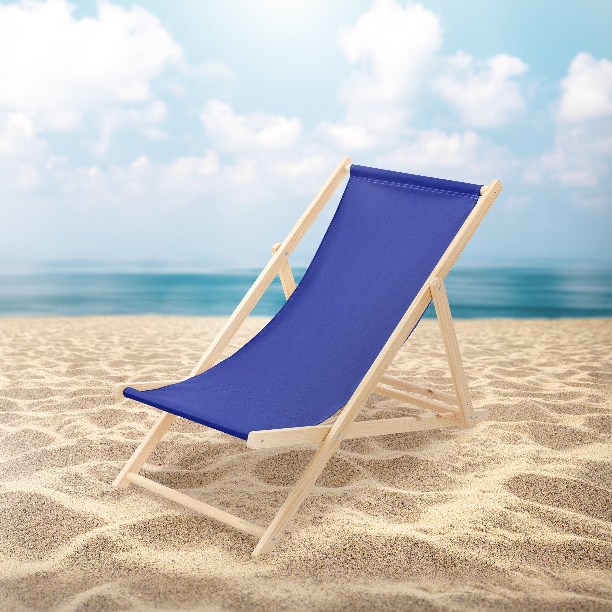 Blauer Liegestuhl am Strand mit Meer und Wolken im Hintergrund.