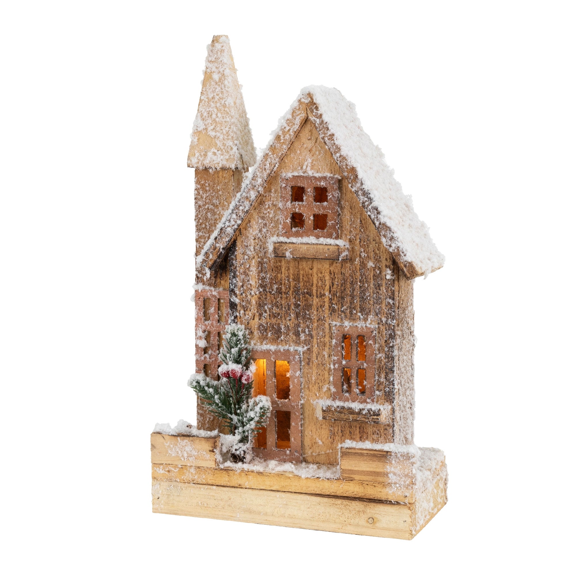 Maison en bois avec de la neige et des lumières, entourée de petites plantes.