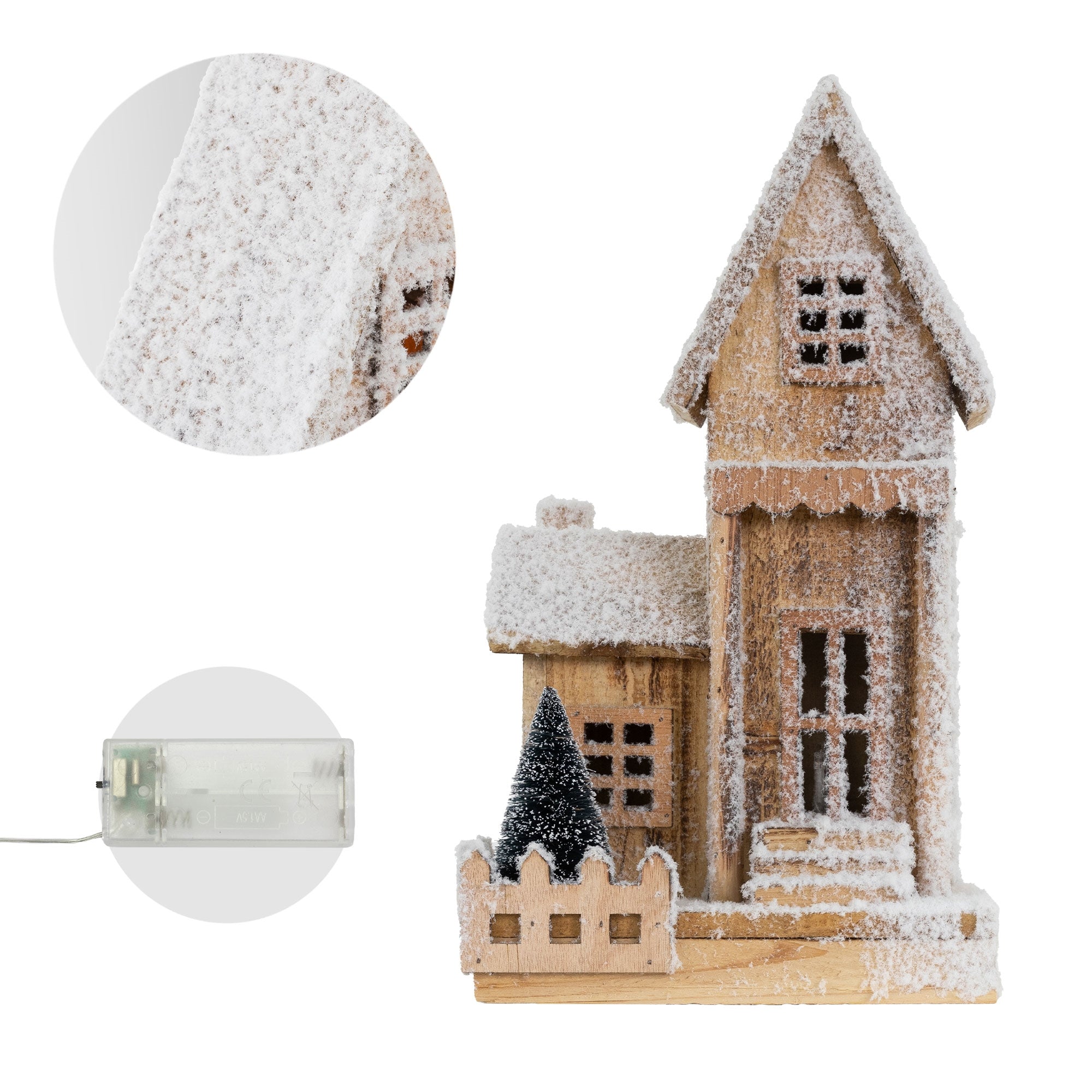 Detailansicht eines Holzhauses mit Schnee und einem kleinen Weihnachtsbaum.
