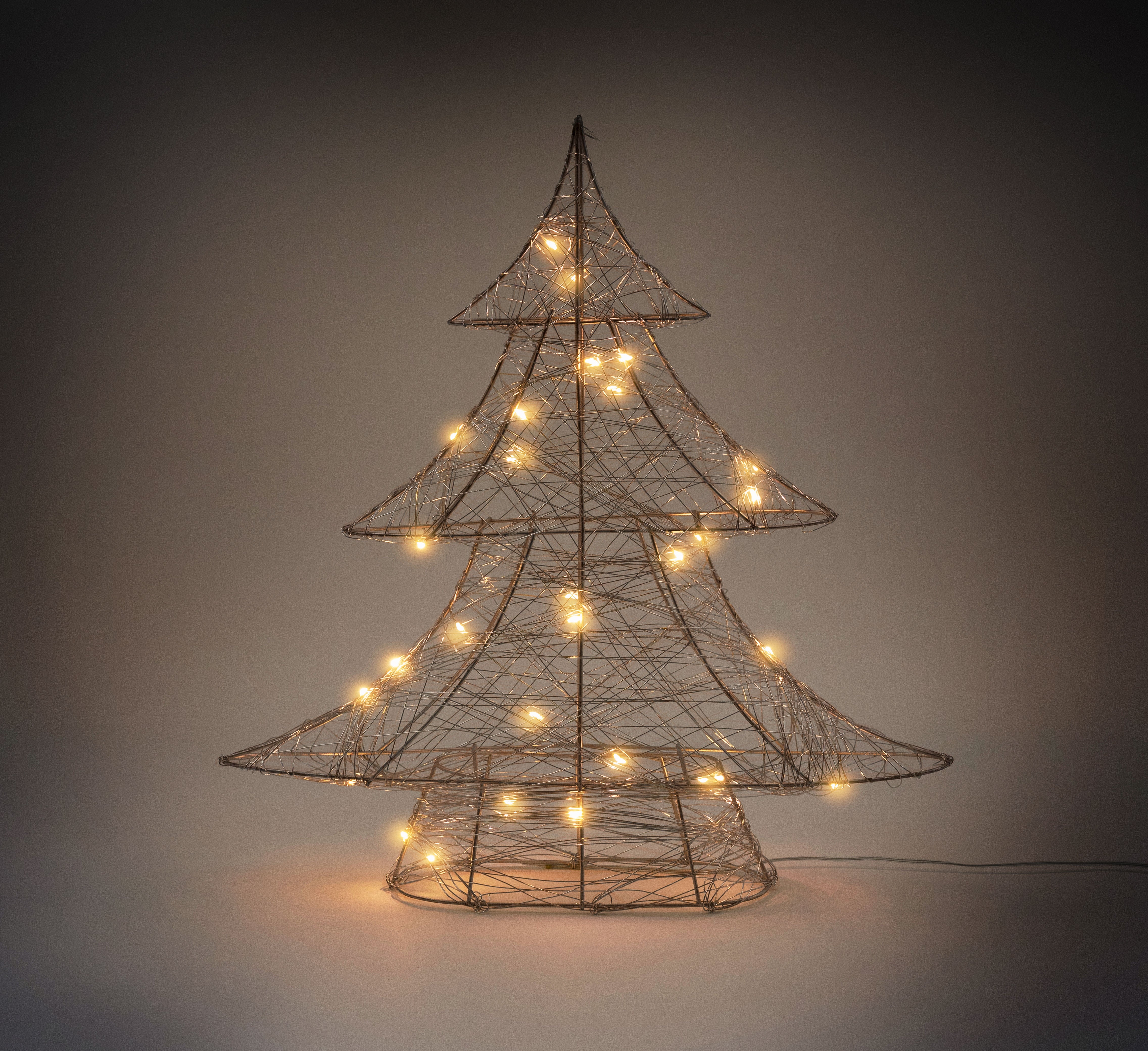 Drahtbaum in Form eines Weihnachtsbaums mit warmweißen Lichtern.