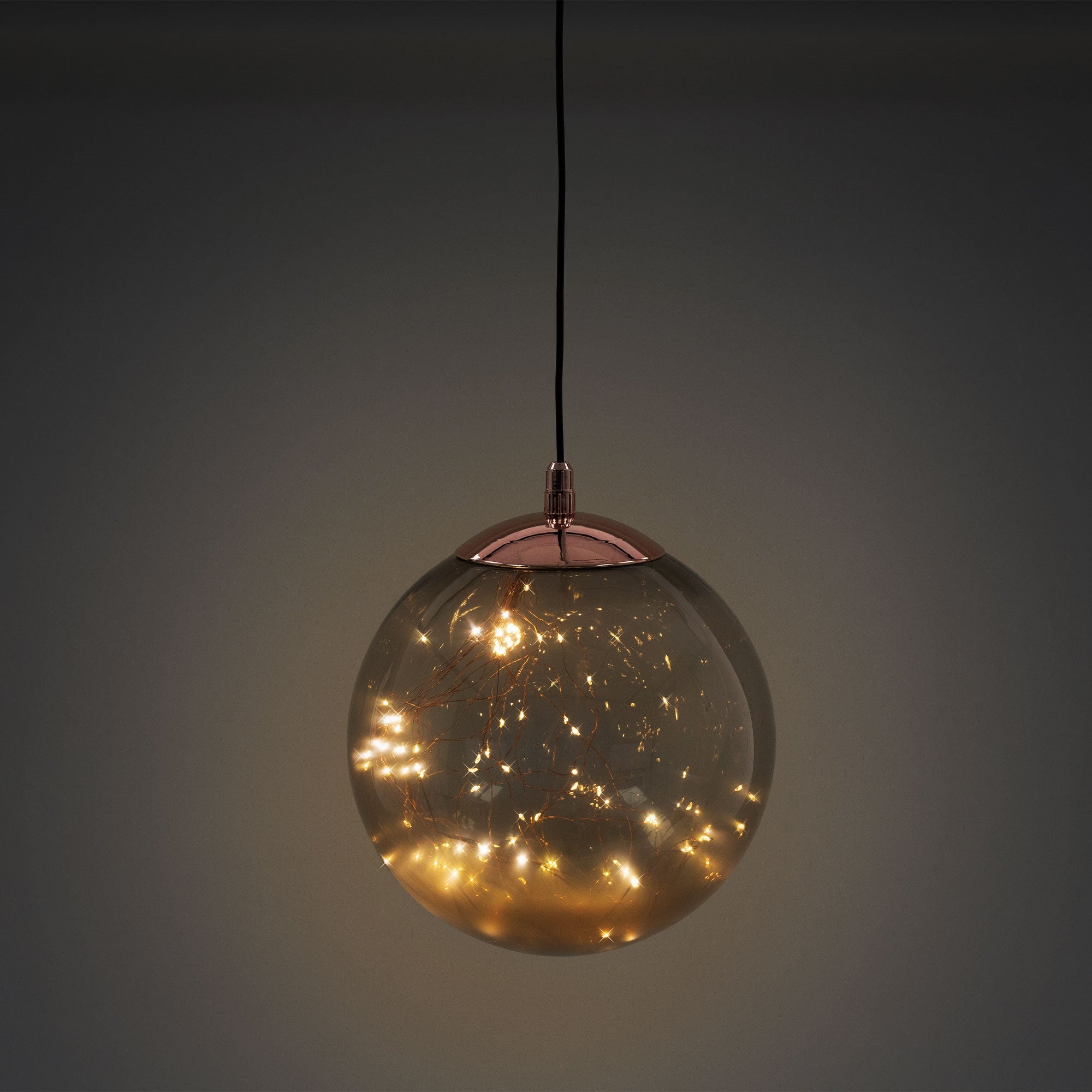Hängende Glaskugel mit warmem Licht im Inneren.