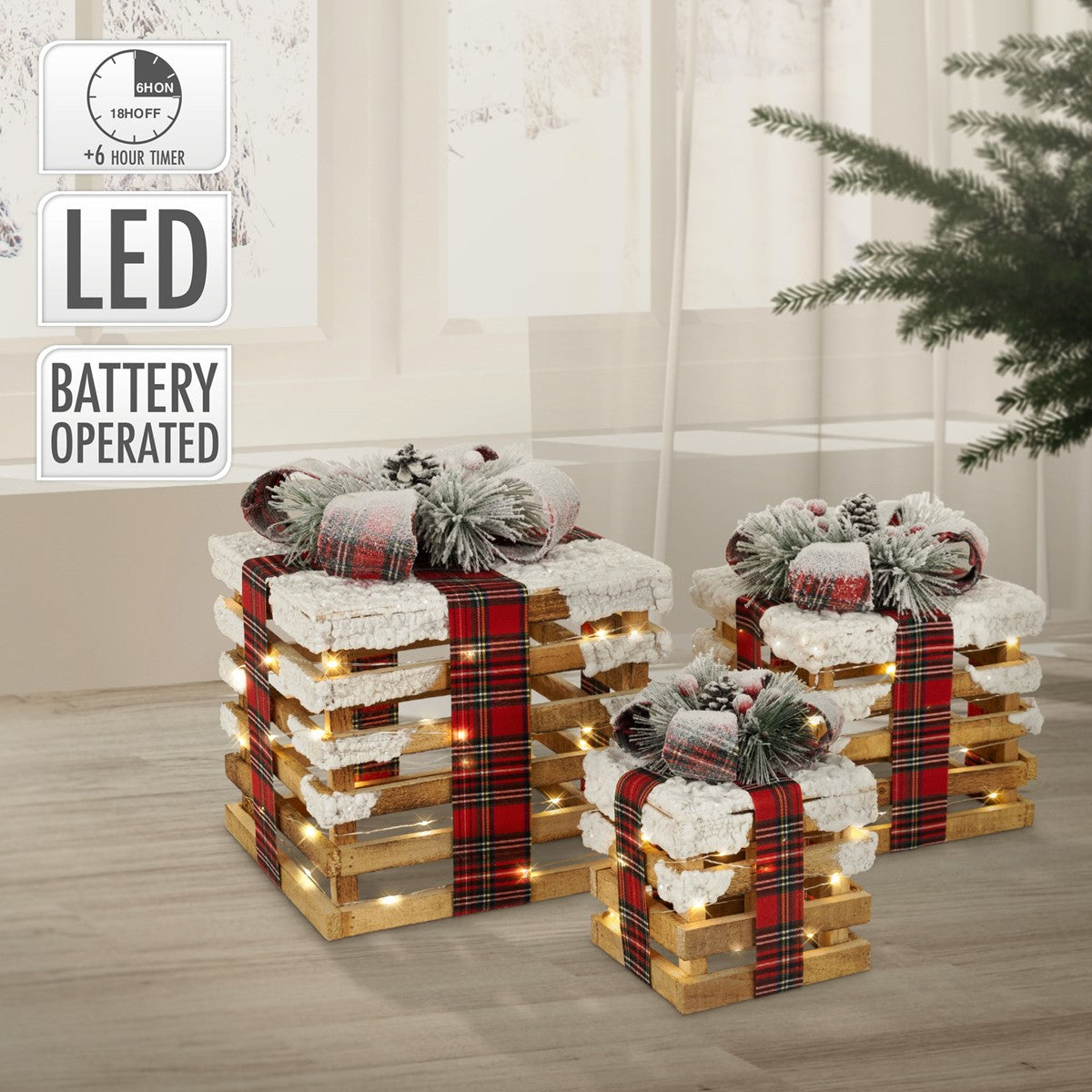 Drei Geschenkkörbe mit LED-Lichtern, dekoriert mit roten Schleifen und Tannenzweigen.