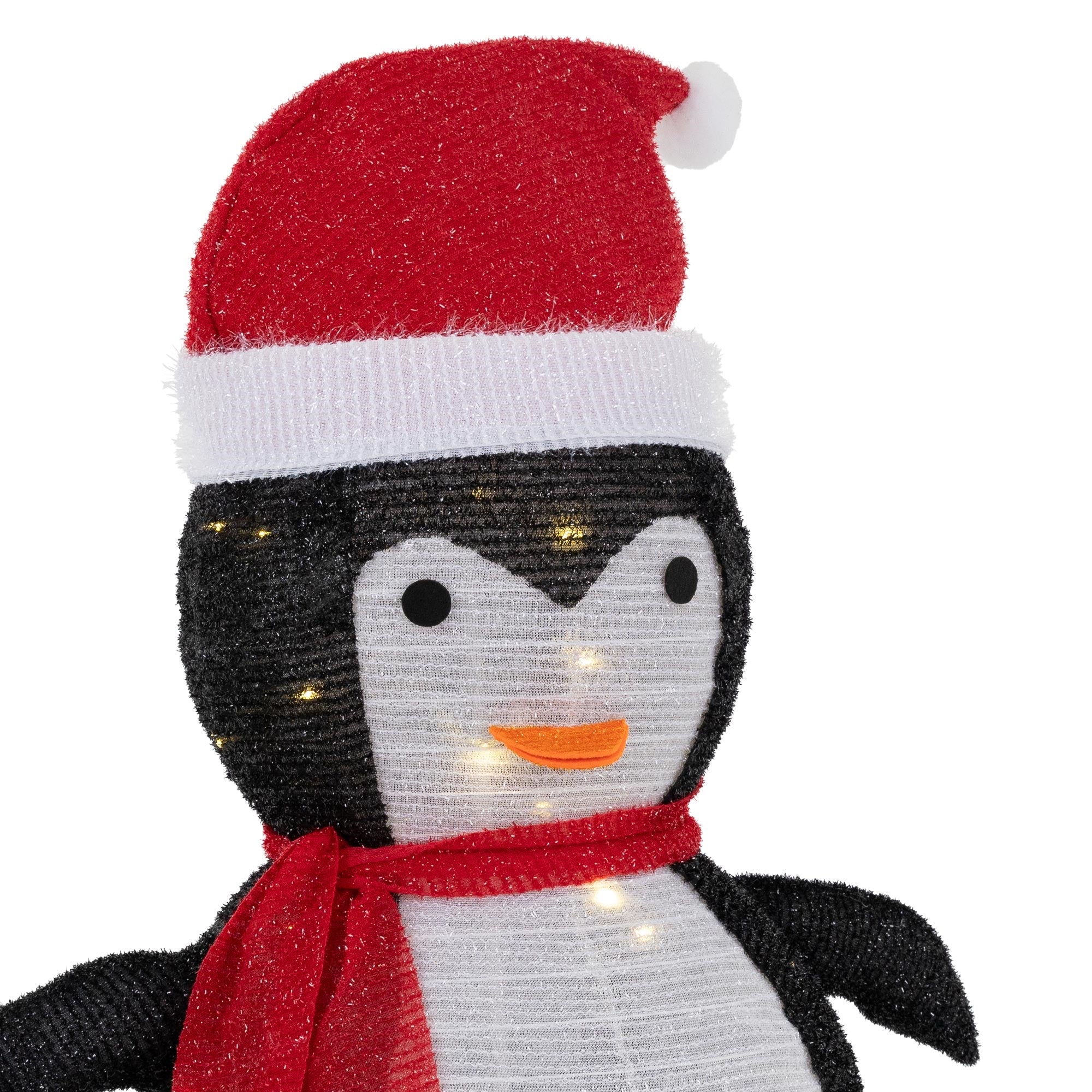 Dekorativer Pinguin mit rotem Hut und Schal, beleuchtet.