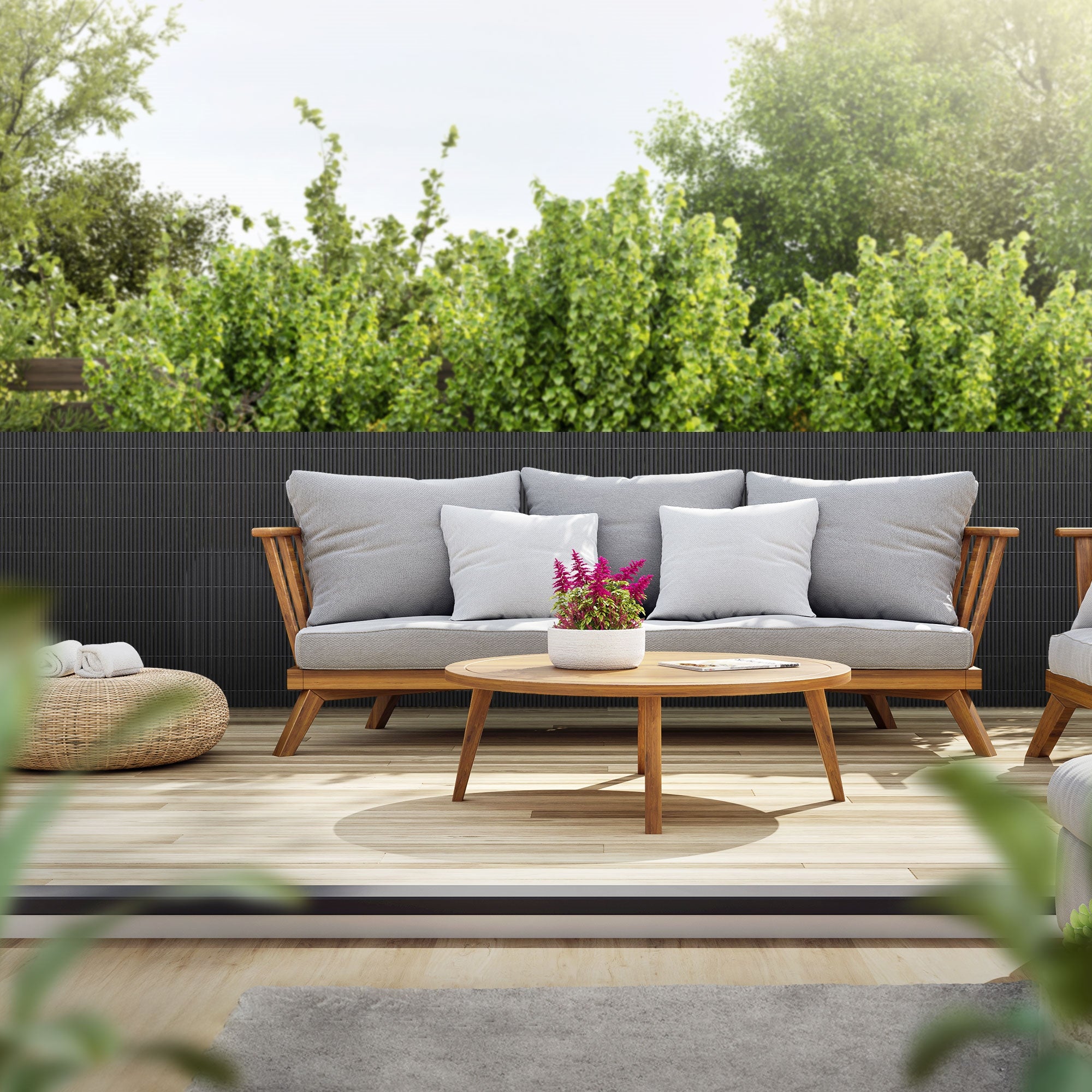 Ein gemütlicher Außenbereich mit Sofa, Tisch und Pflanzen.