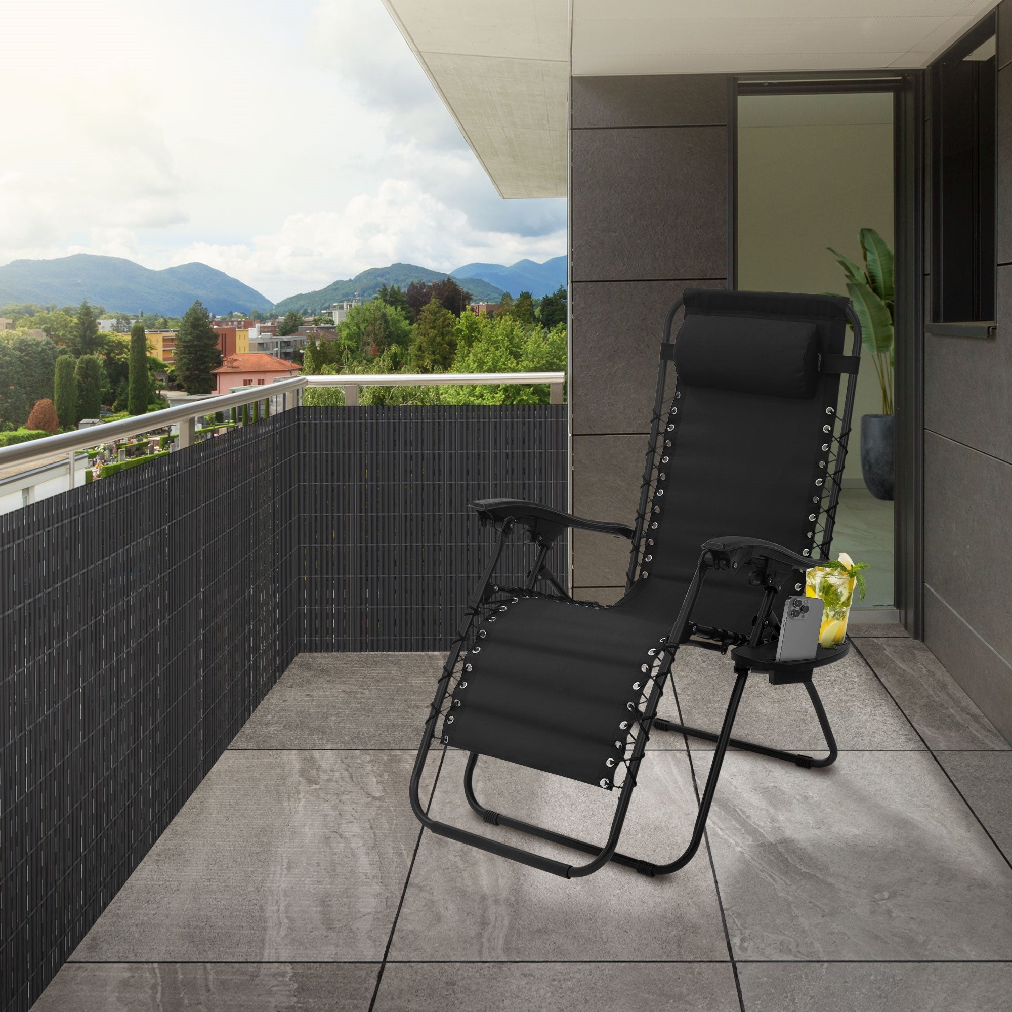 Balkon mit Liegestuhl und Sichtschutzzaun, umgeben von einer Landschaft.