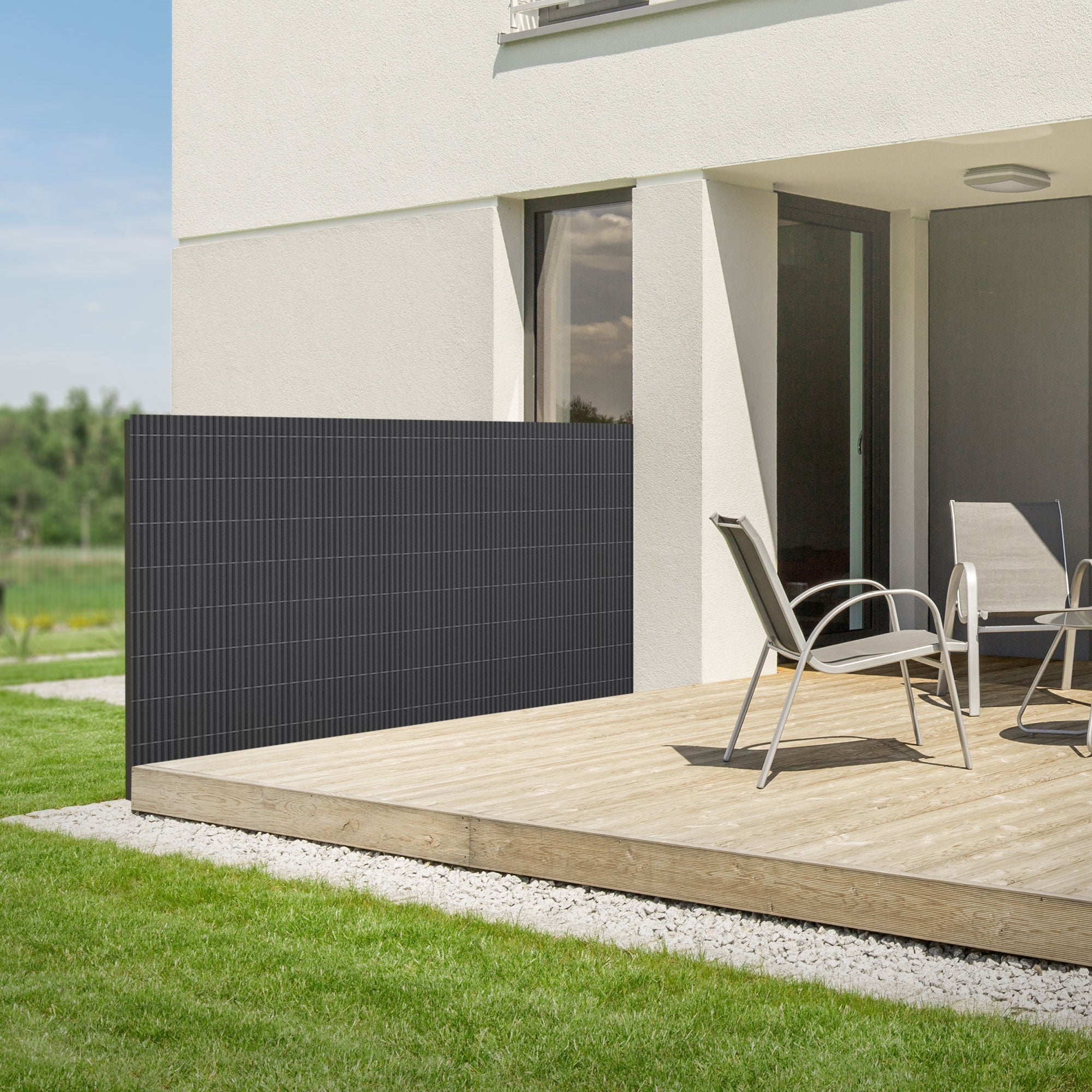 Terrasse mit Anthrazit Sichtschutz, Holzdeck und zwei Stühlen.