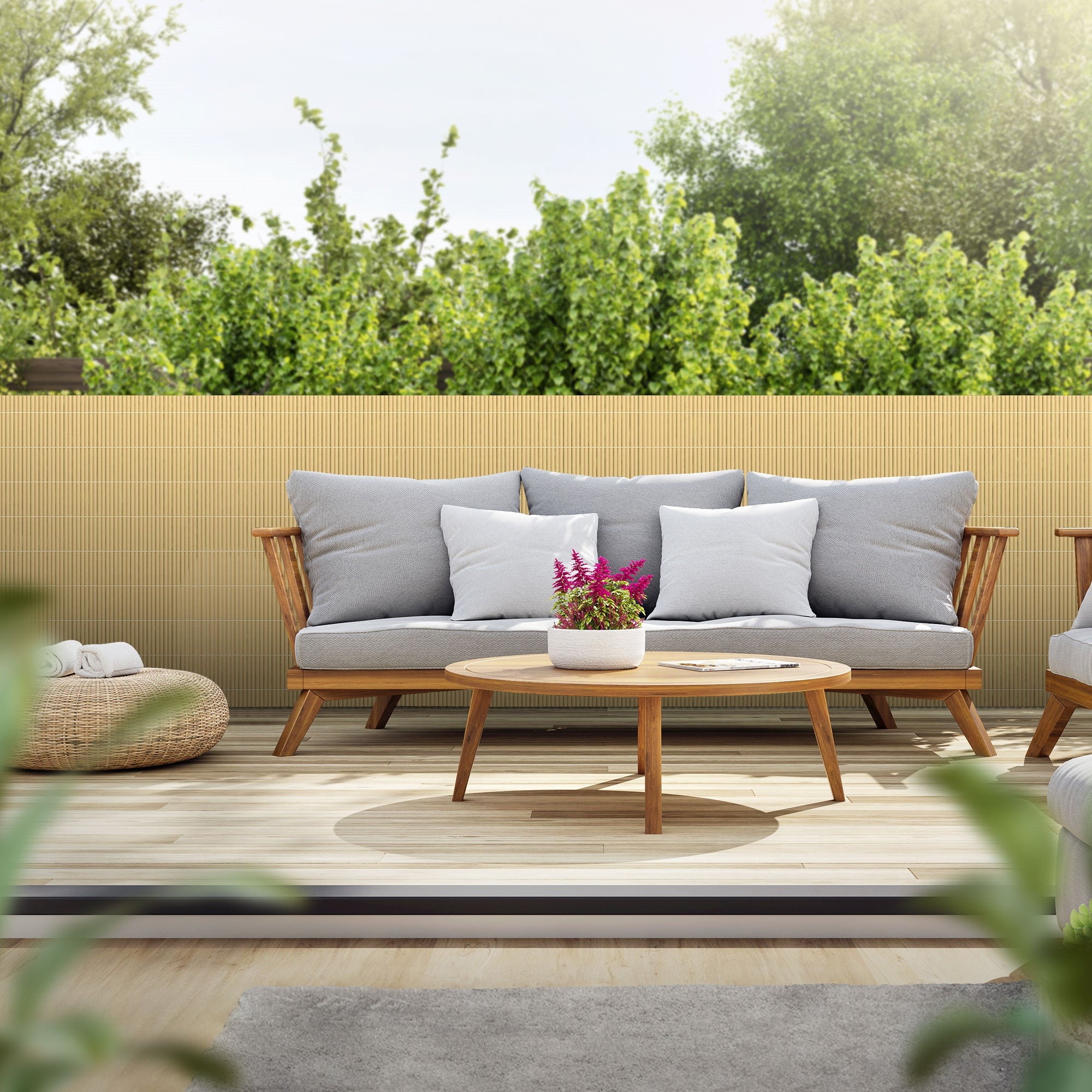 Hyggeligt siddeområde med grå sofa, rundt bord og planter i baggrunden.