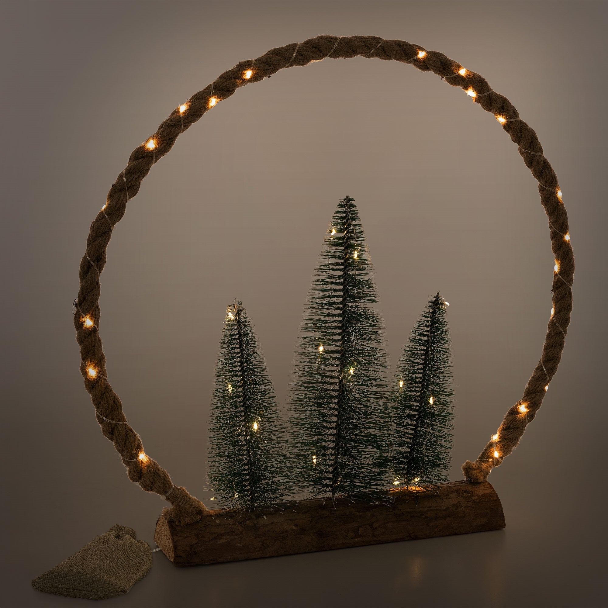Decorazione con tre alberi di Natale in un cerchio di corda, illuminata.