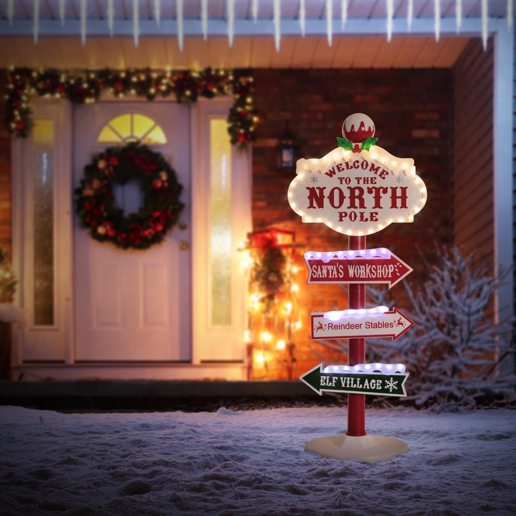 Világító tábla 'Welcome to the North Pole' felirattal és irányjelző nyilakkal.