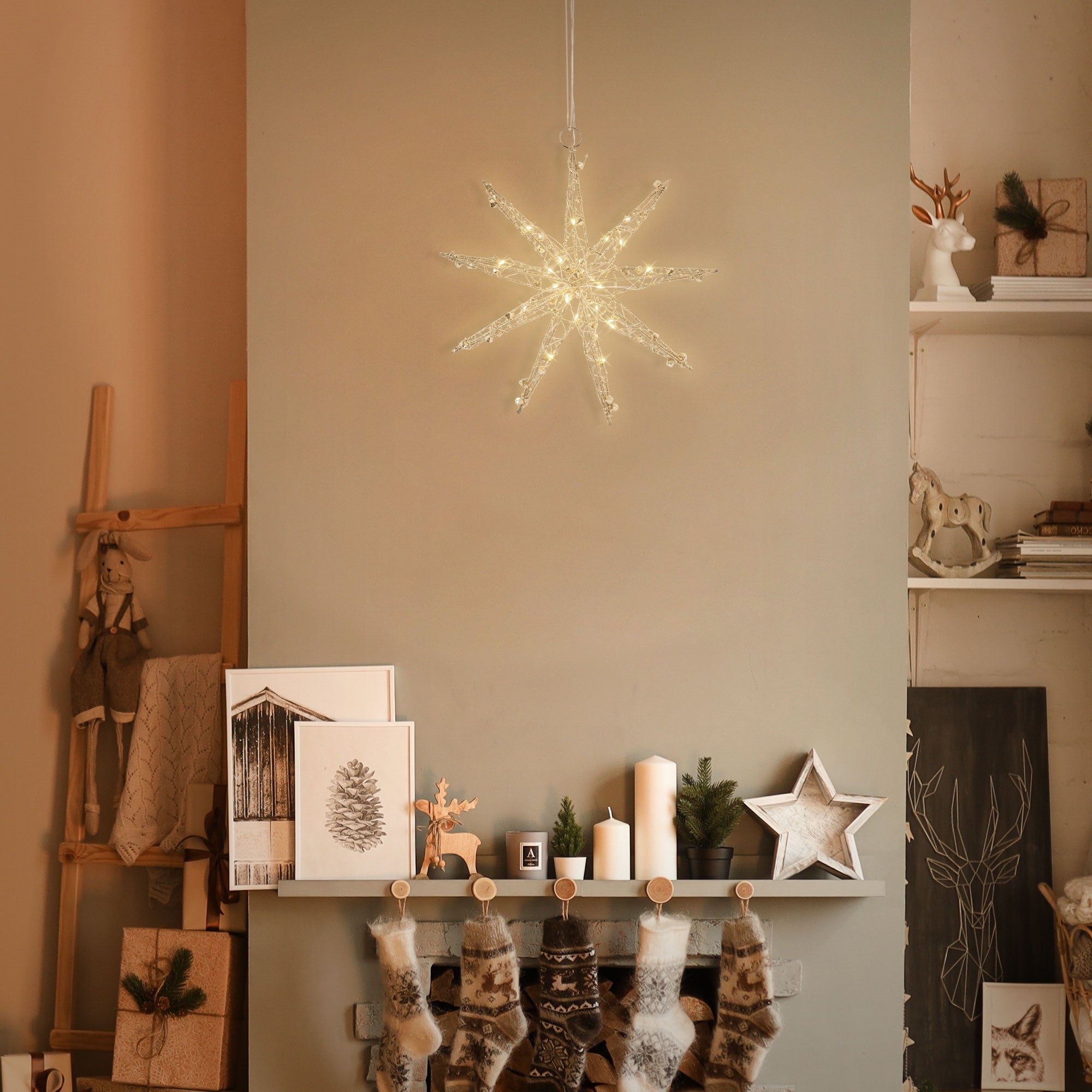Une étoile décorative en lumières suspendue au-dessus d'une cheminée avec des chaussettes de Noël.