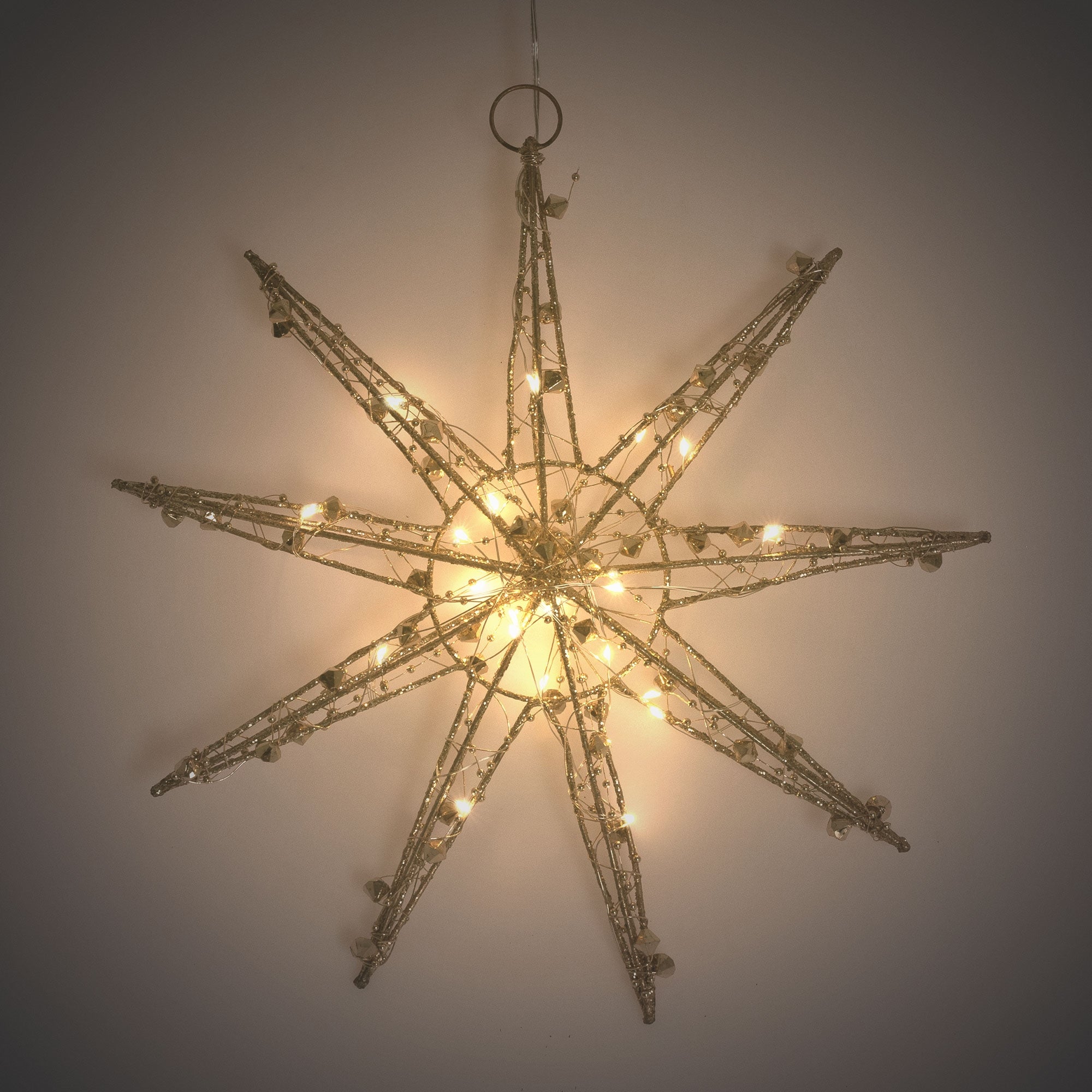 Une grande étoile de Noël lumineuse suspendue à un mur.