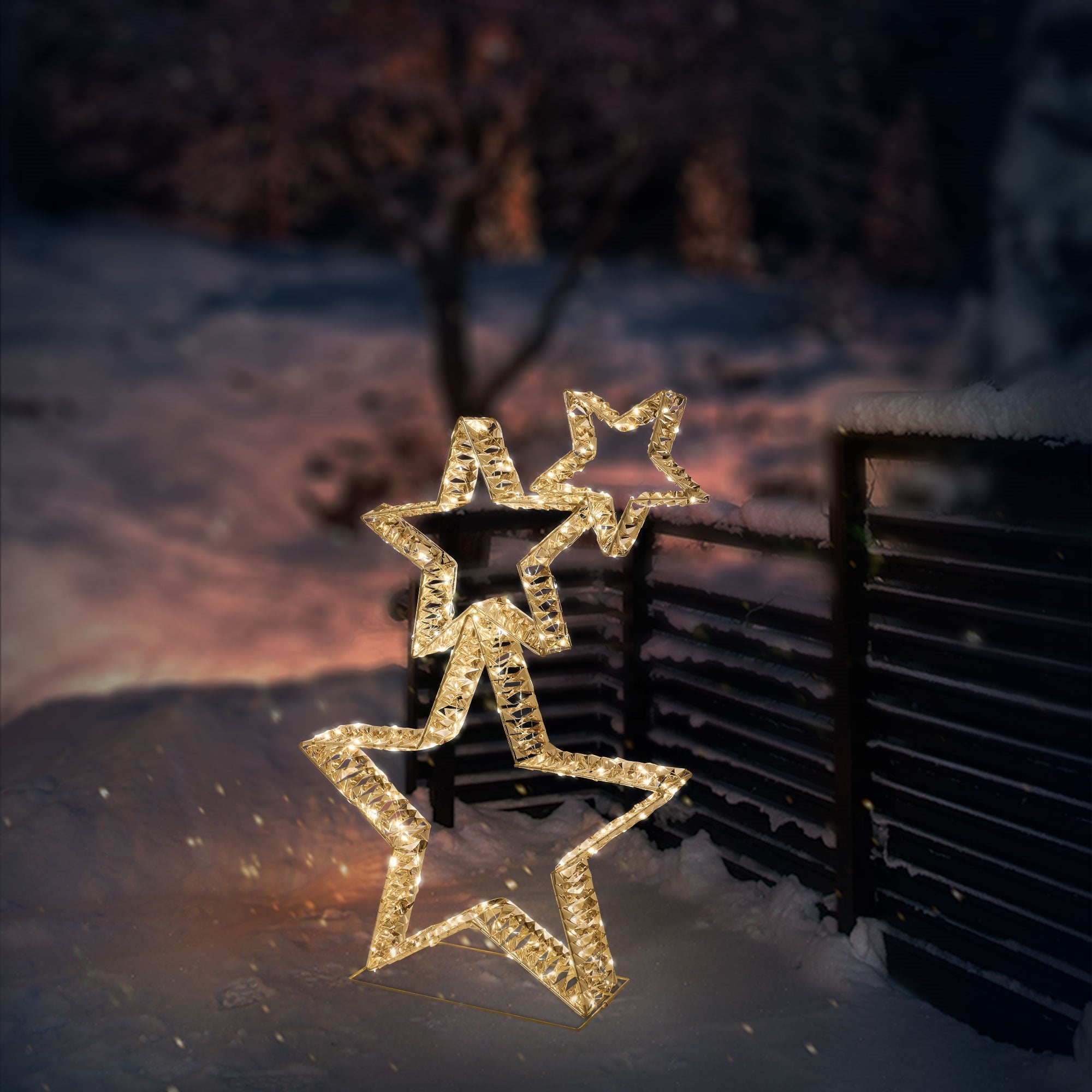 Tres estrellas brillantes de luces frente a un fondo oscuro y nevado.