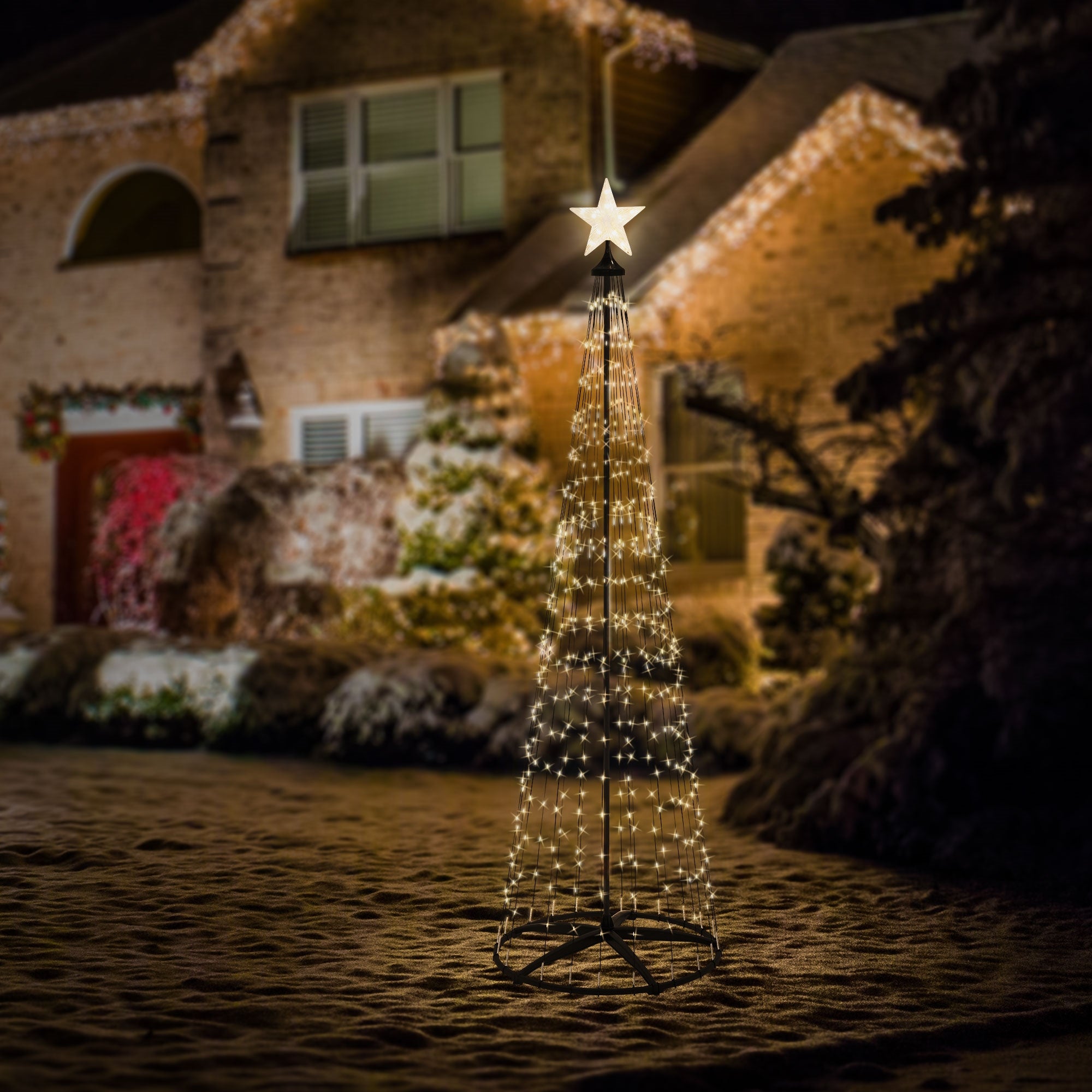 Beleuchteter Weihnachtsbaum aus Lichtern vor einem Haus.
