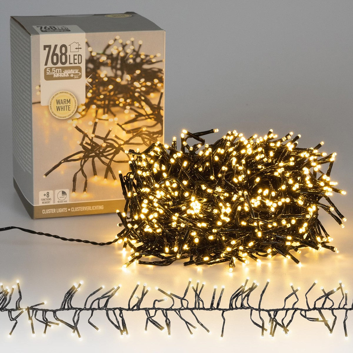 Ein Karton mit Clusterlichtern und einer Lichterkette auf einem Tisch.