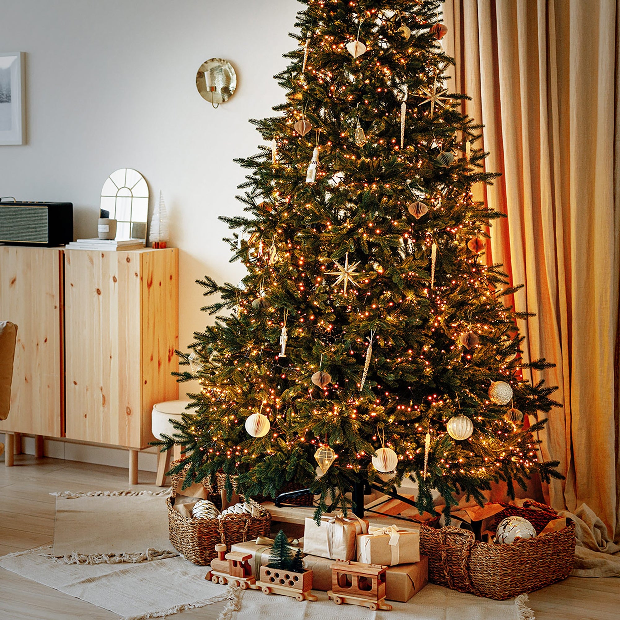 Ein geschmückter Weihnachtsbaum mit Lichtern und Geschenken darunter.