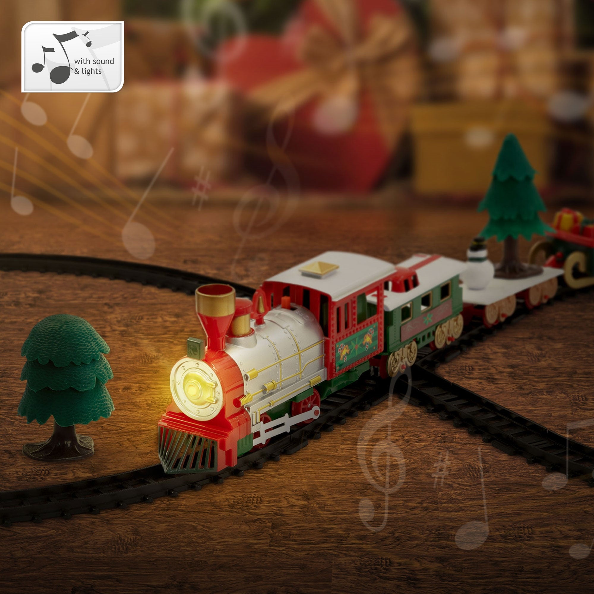 Spielzeugzug mit Lichtern und Tannenbäumen auf einer Schiene, im Hintergrund Geschenke.