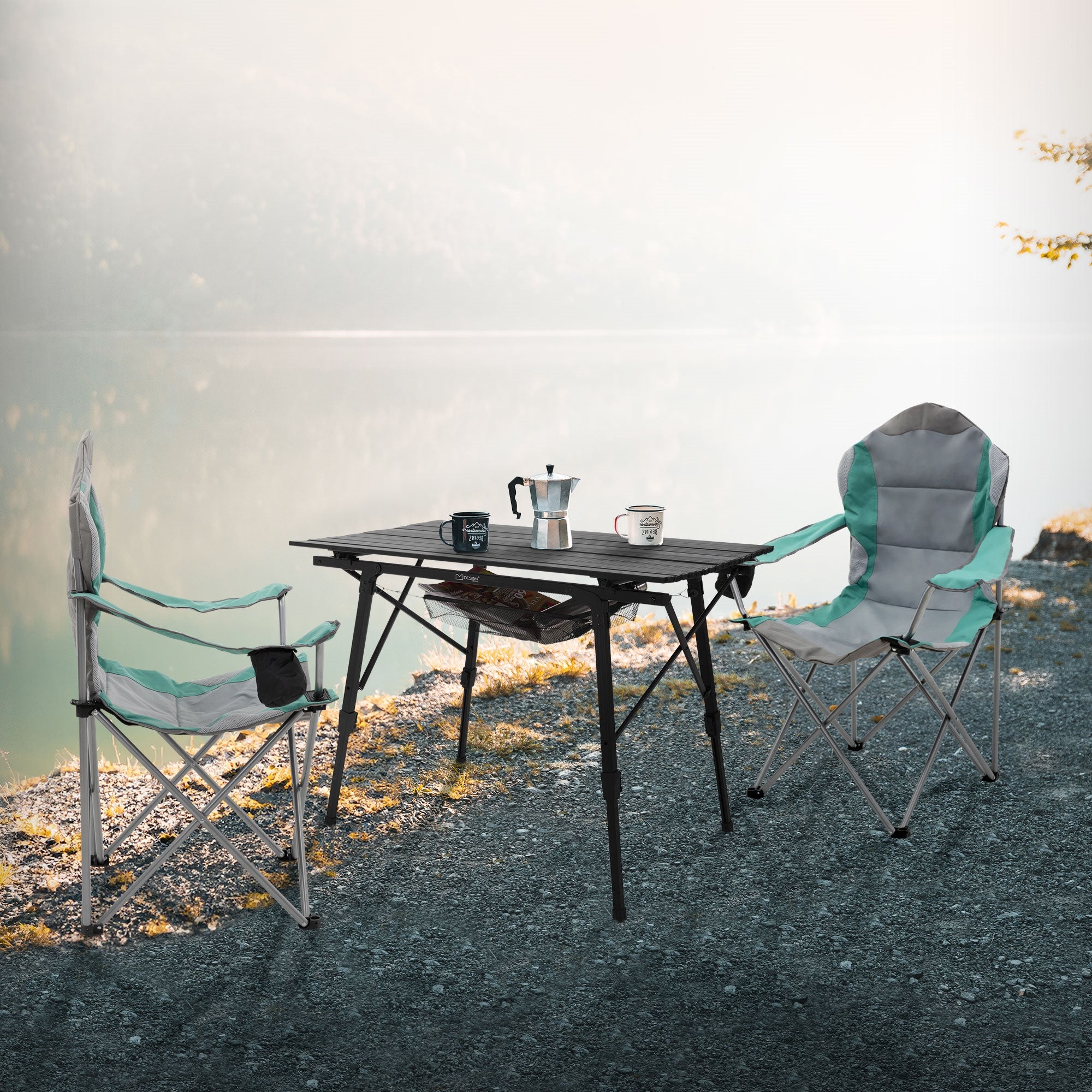 Zwei Campingstühle und ein Tisch am Ufer eines Sees mit Tassen und einer Kaffeekanne.
