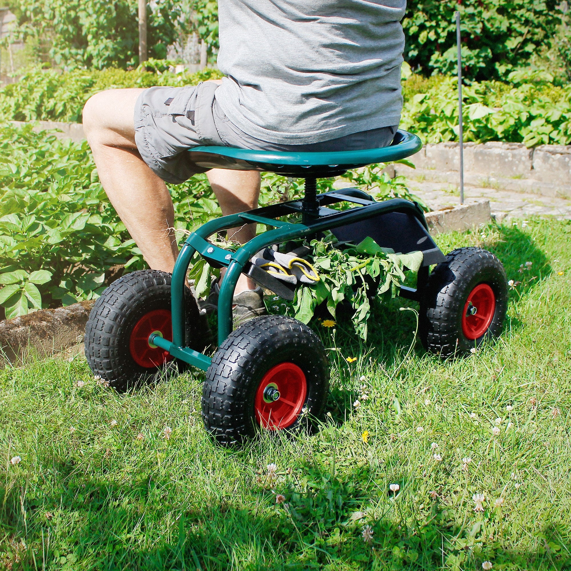 Person sitting in a wheelchair in the garden, surrounded by plants.