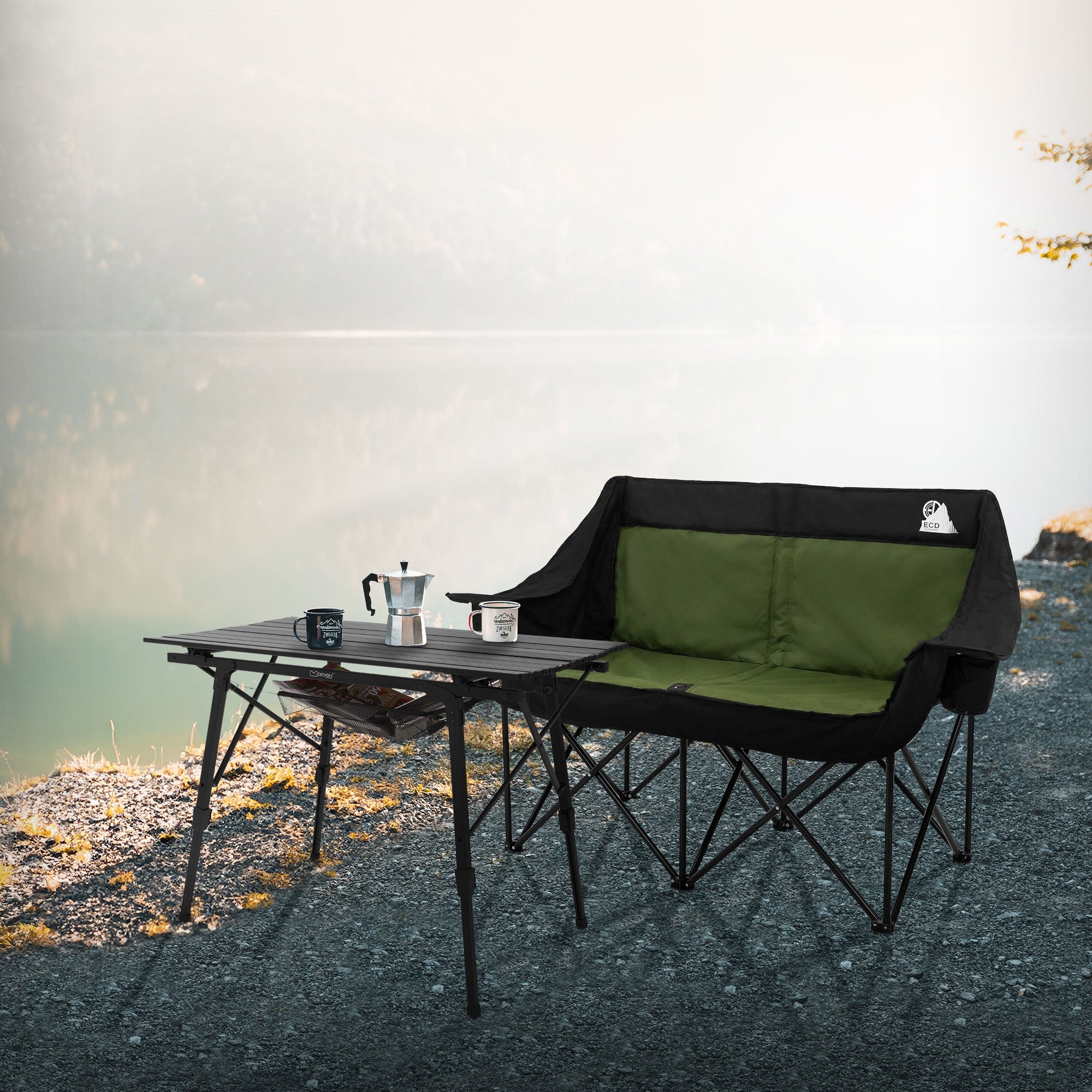 Campingstuhl und Tisch am Ufer eines Sees, ruhige Landschaft im Hintergrund.