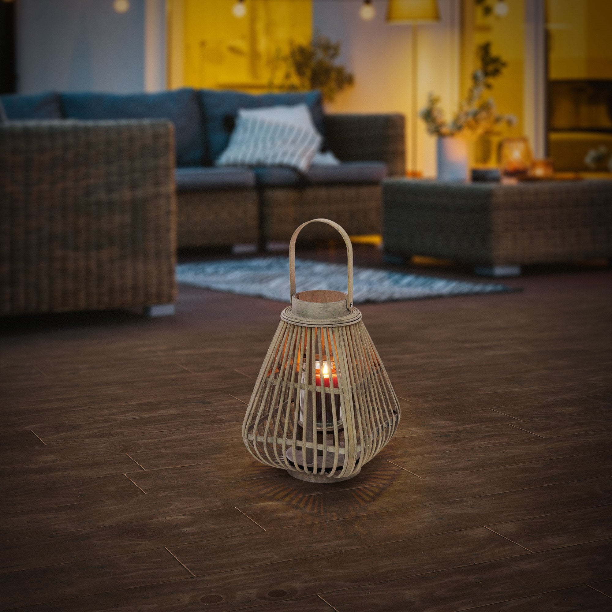 A rattan lantern is placed on a wooden floor in a cozy room.