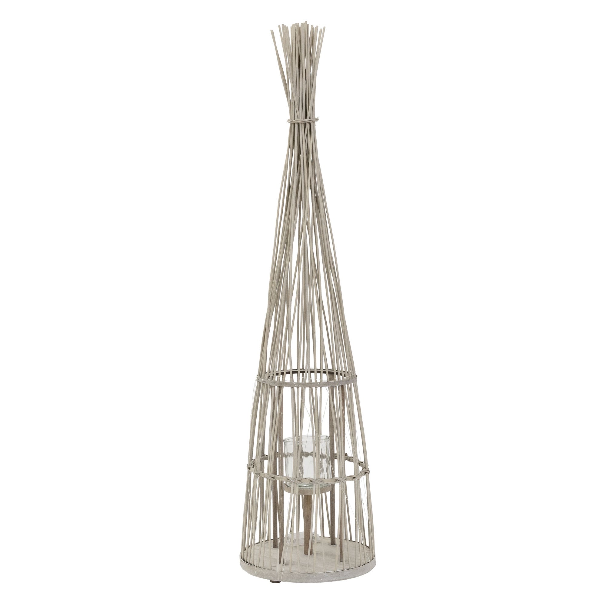 Eine hohe Laterne aus Rattan mit einem Glasbehälter in der Mitte.