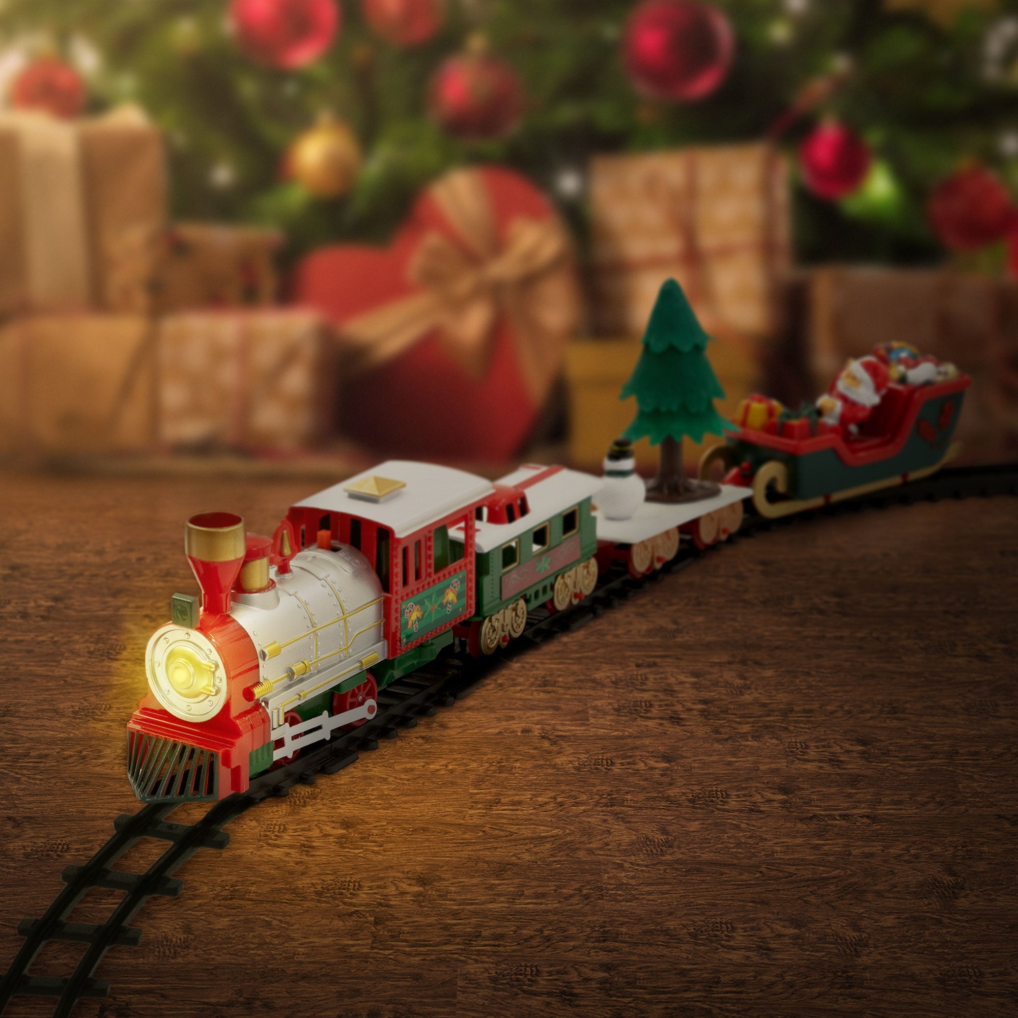 Close-up of a toy train with Christmas tree and sled.