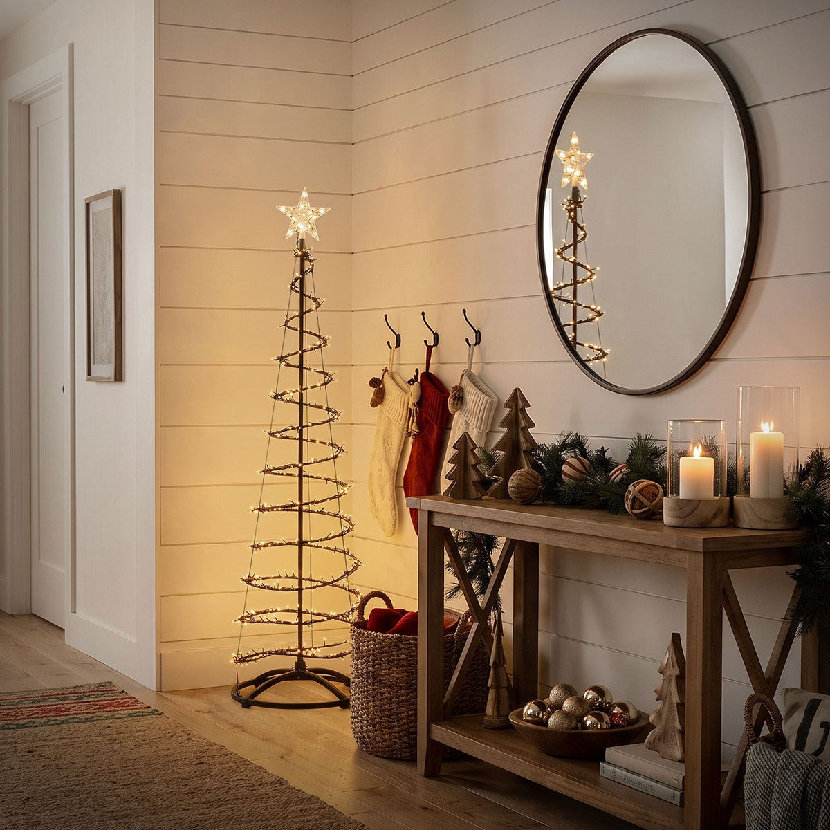 Beleuchteter spiralförmiger Metall-Weihnachtsbaum mit Stern neben einer Konsole mit Kerzen, Zweigen und Dekoration.