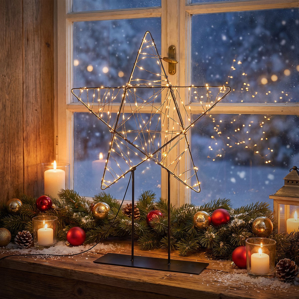 Ein beleuchteter Weihnachtsstern steht auf einem Tisch vor einem Fenster mit Schnee.