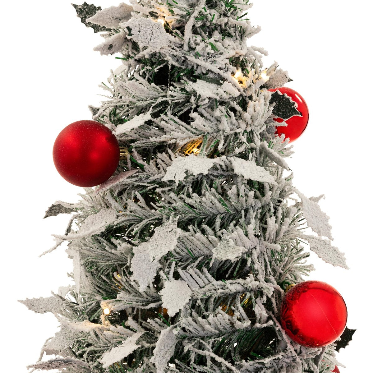 Nahaufnahme eines künstlichen Weihnachtsbaums mit roten Kugeln und schneebedeckten Zweigen.