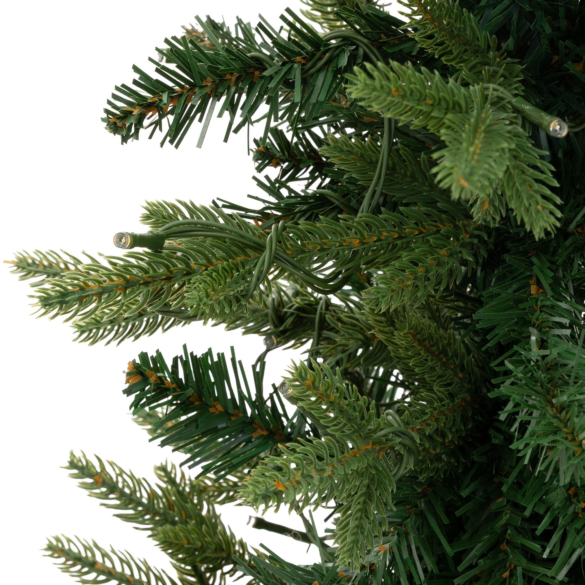 Close-up of green fir branches of an artificial Christmas tree.