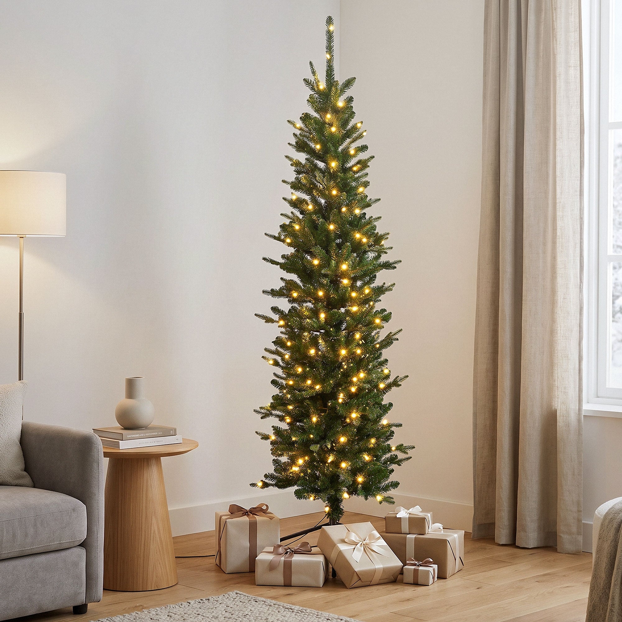 Weihnachtsbaum mit Lichtern in einem hellen Raum, umgeben von Geschenken.
