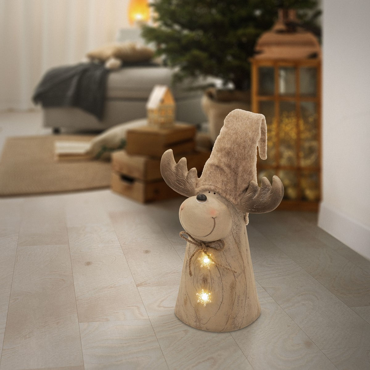 Eine Holzfigur mit beigem Hut und Lichtern steht in einem Raum.