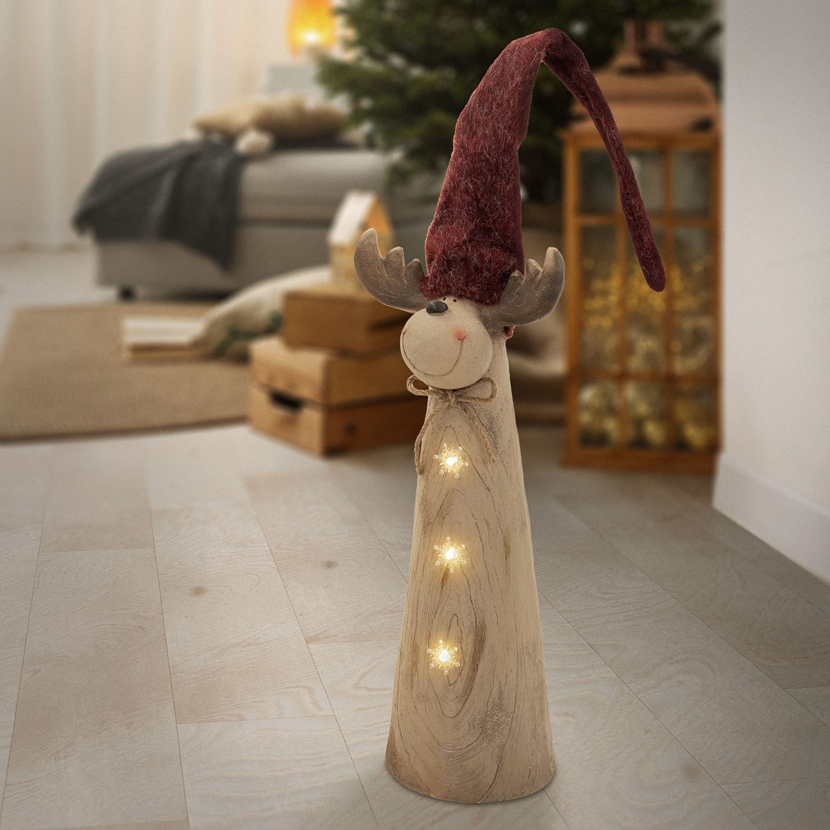 Eine Holzfigur mit rotem Hut und Lichtern steht in einem Raum.
