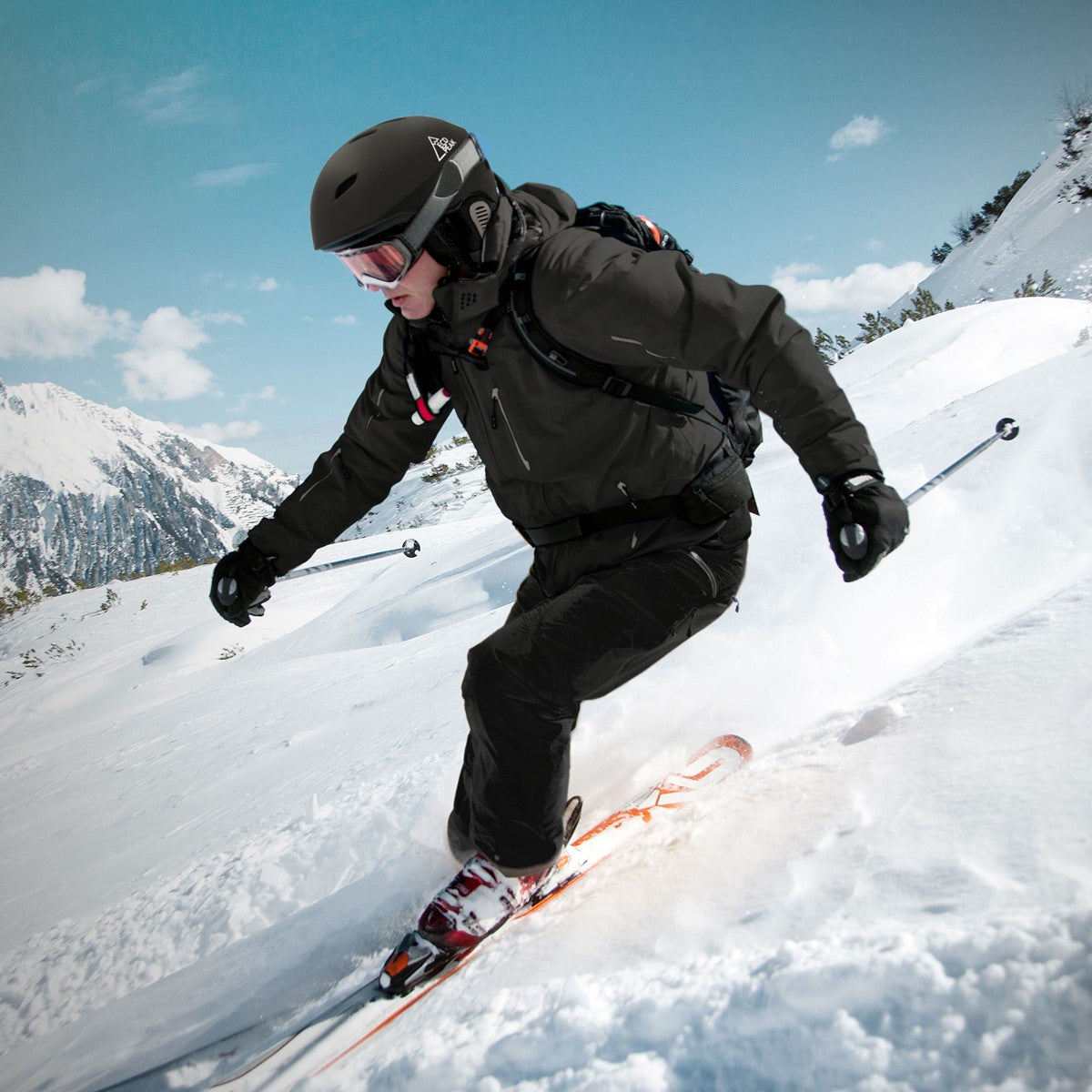 Skifahrer in schwarzer Jacke fährt durch verschneite Landschaft.