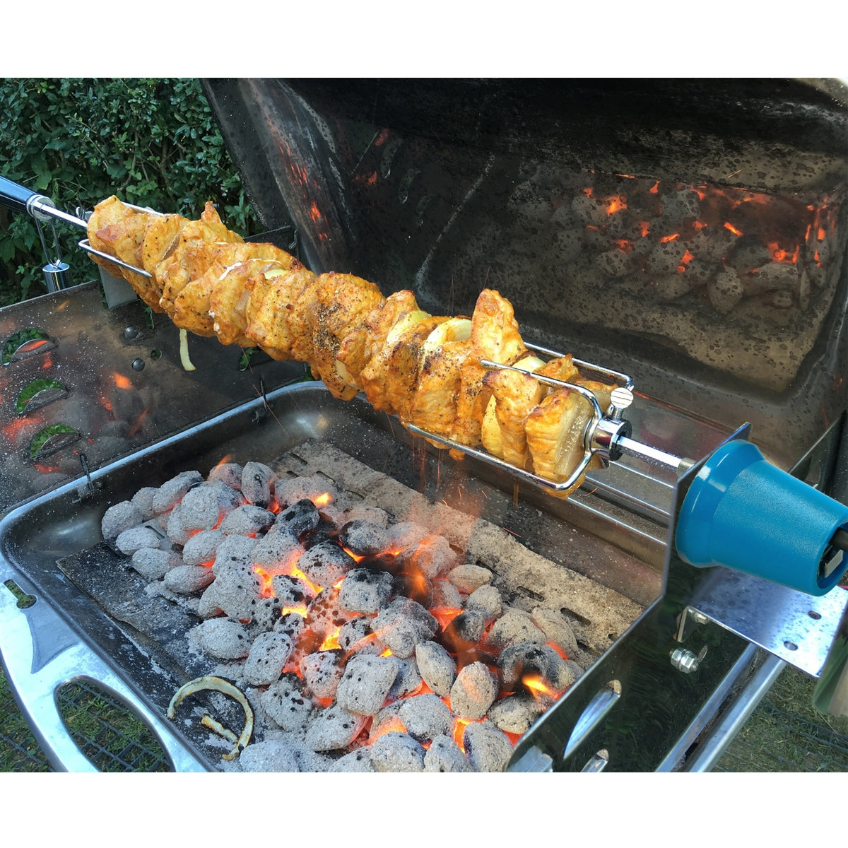 Pincho con carne marinada en una parrilla sobre brasas ardientes.
