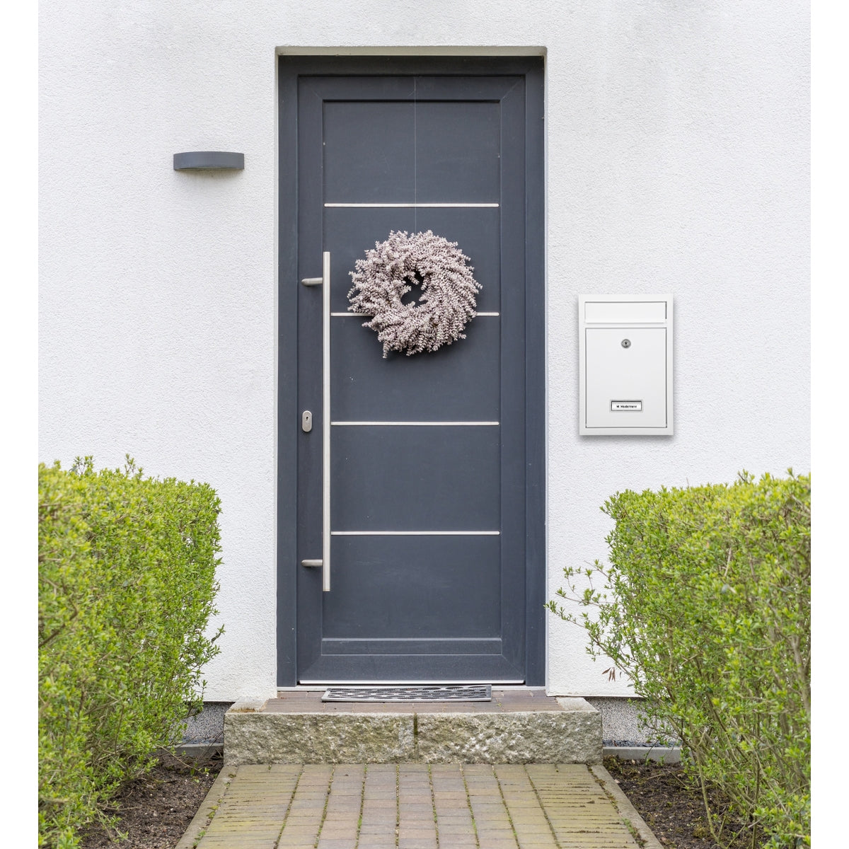 Front door with a wreath and a white mailbox.