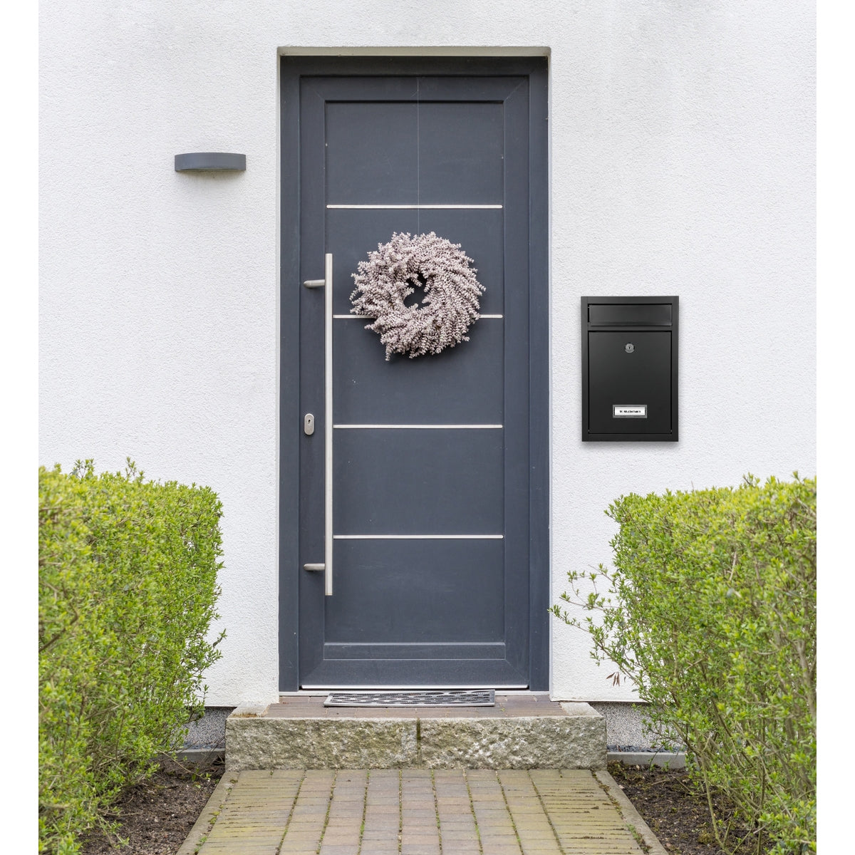 Haustür mit Kranz und schwarzem Briefkasten.
