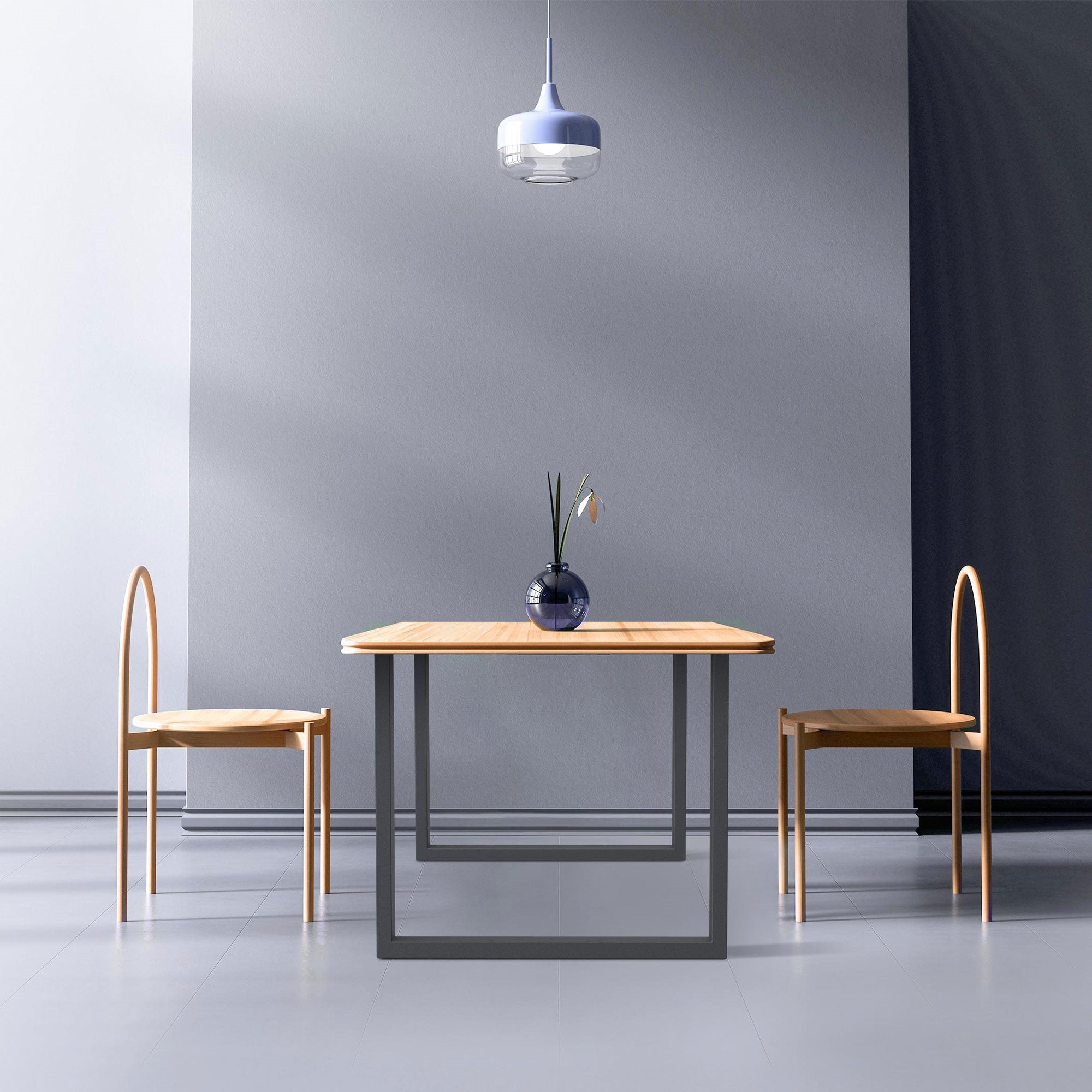 Ein minimalistischer Tisch mit einer Vase und zwei Stühlen in einem hellen Raum.