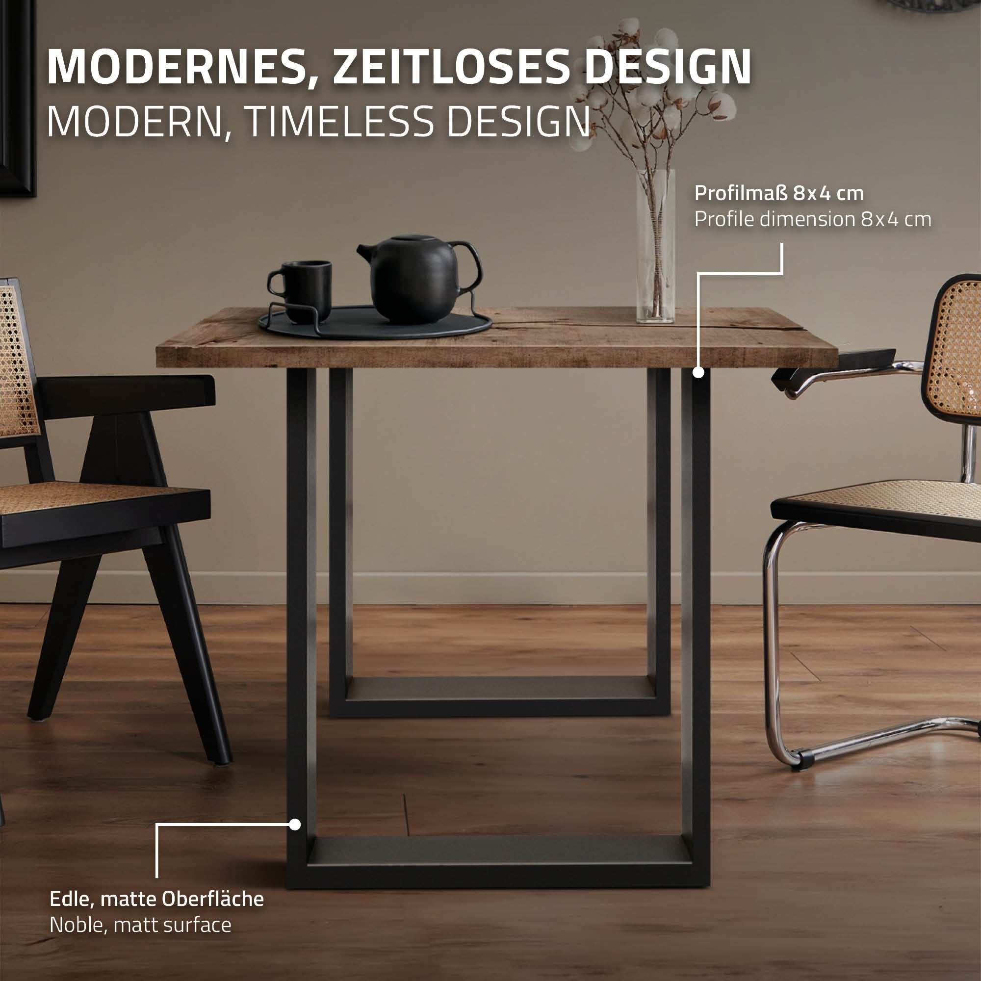 Holztisch mit schwarzem Geschirr und zwei Stühlen in einem modernen Raum.