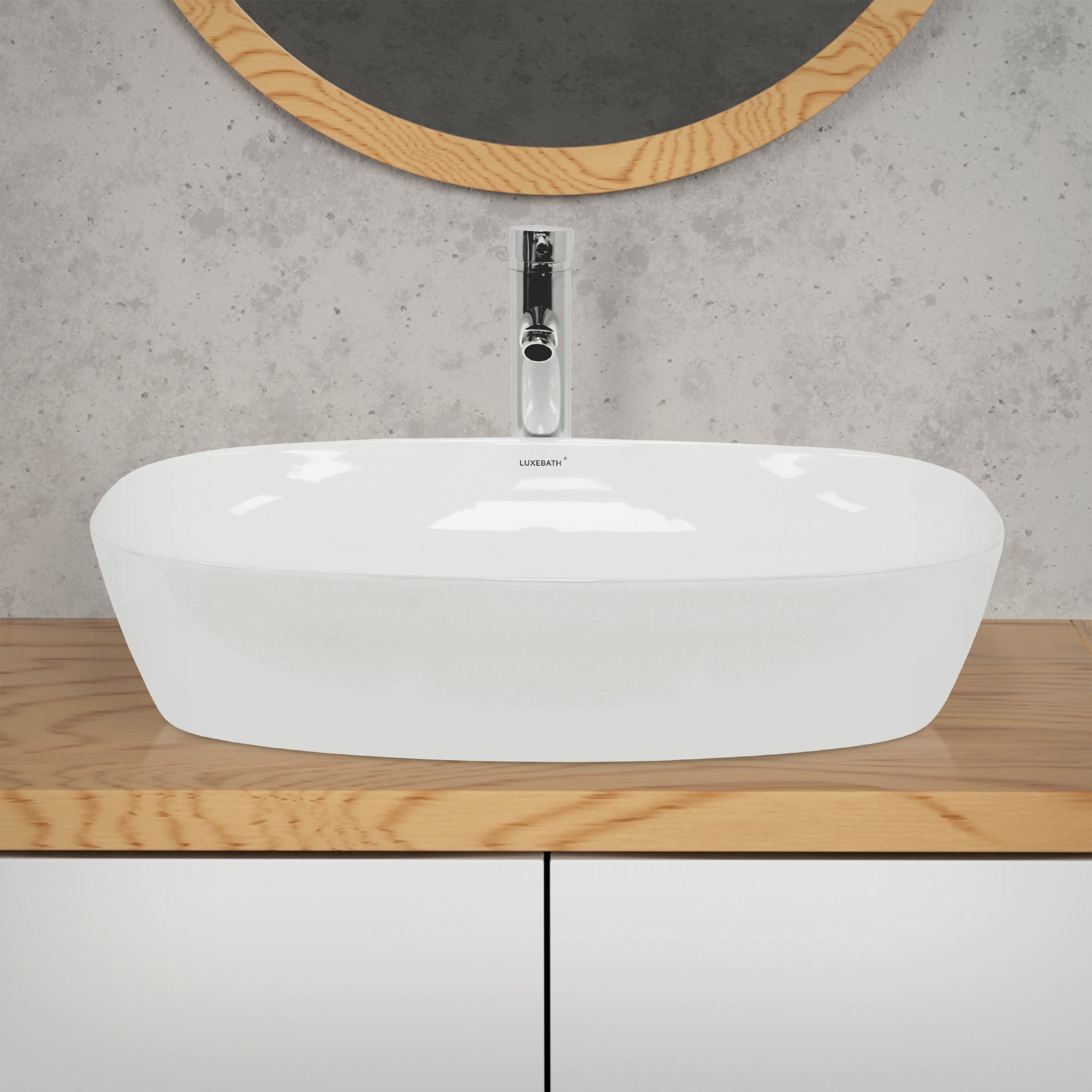 Ovale wastafel van wit materiaal op een houten plank voor een grijze muur.