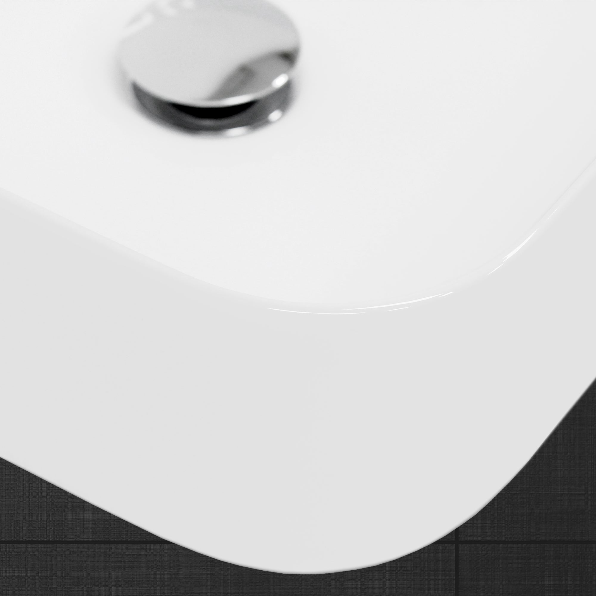 Detailopname van de rand van een witte wastafel.