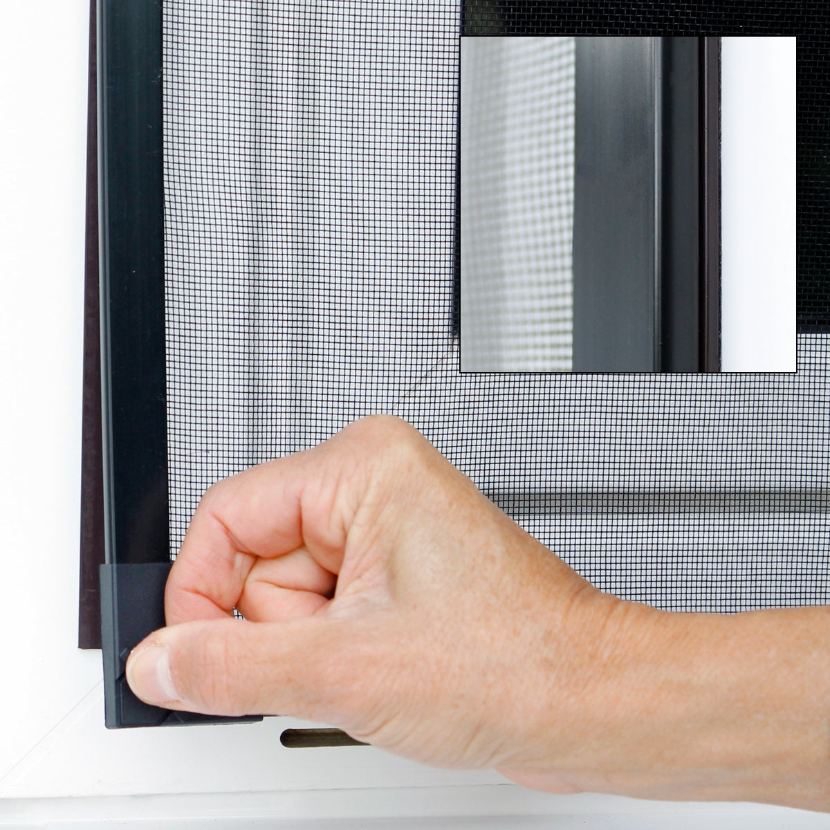 Hand, die ein Insektenschutzgitter an einem Fenster anbringt.