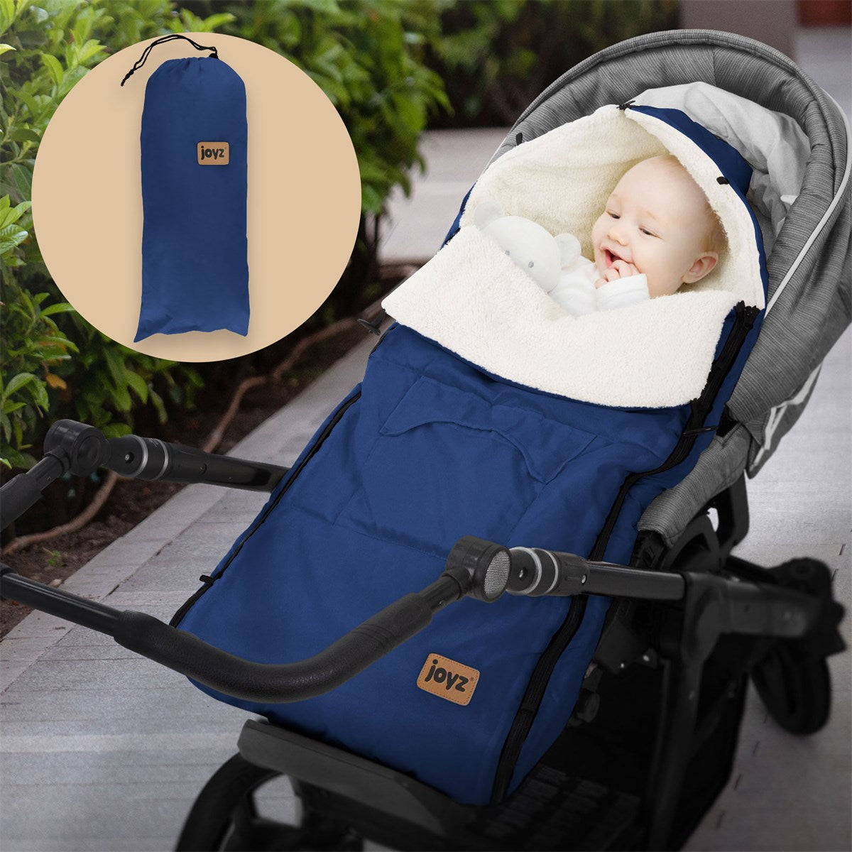 Blue baby footmuff in a stroller, with a toy in the baby's hand.