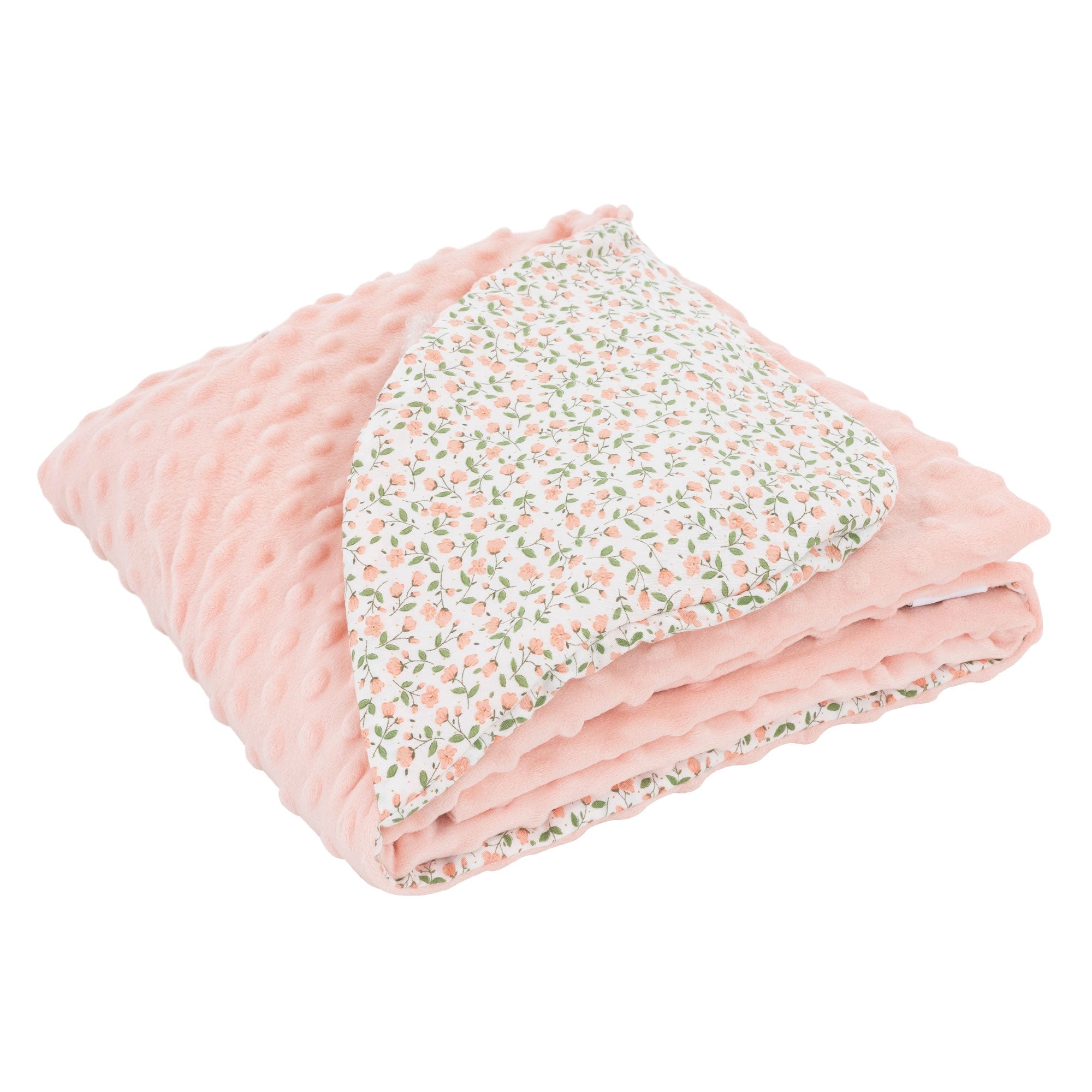 Couverture rose pliée avec motif floral sur fond blanc.