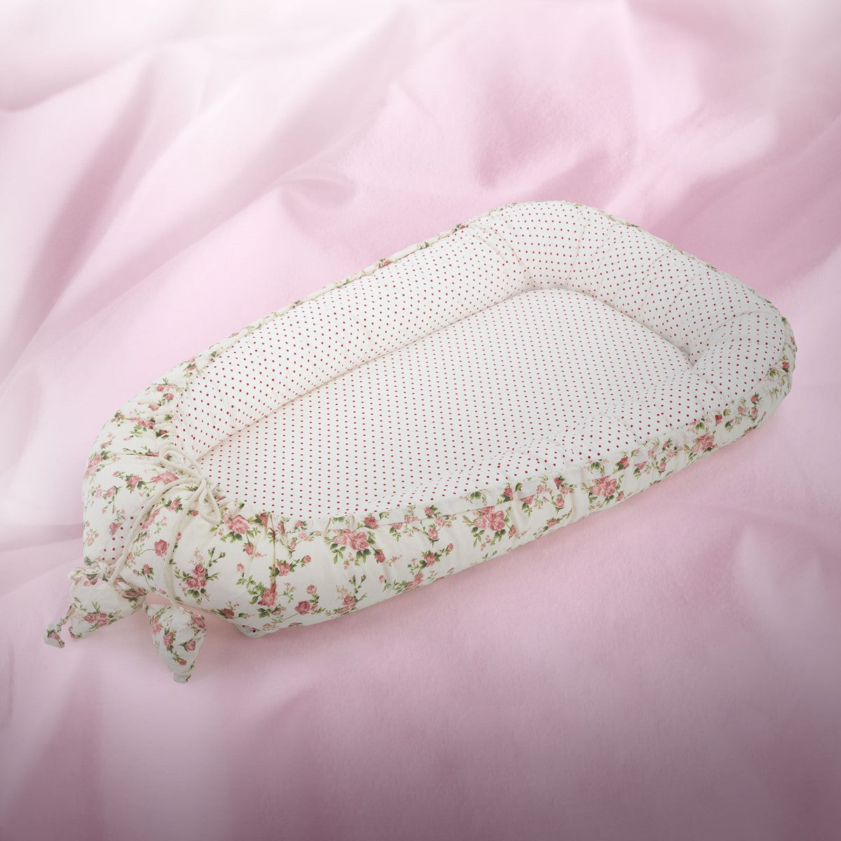 Rundkissen mit floralen Mustern auf rosa Untergrund.
