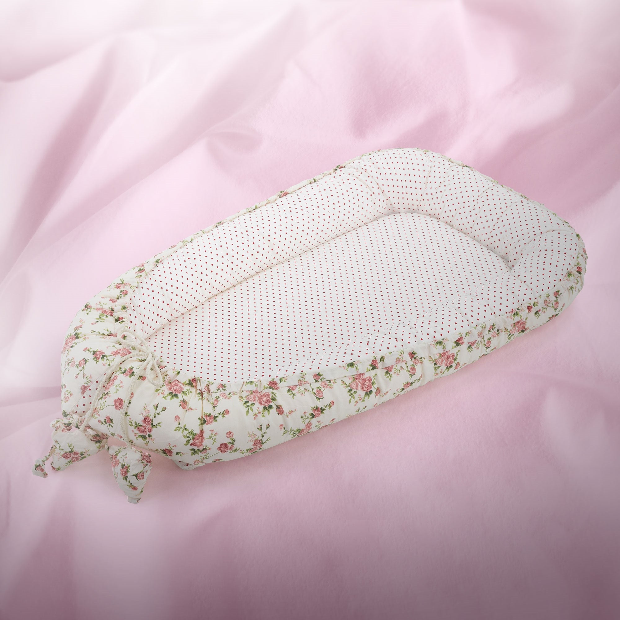 Coussin rond avec des motifs floraux sur fond rose.